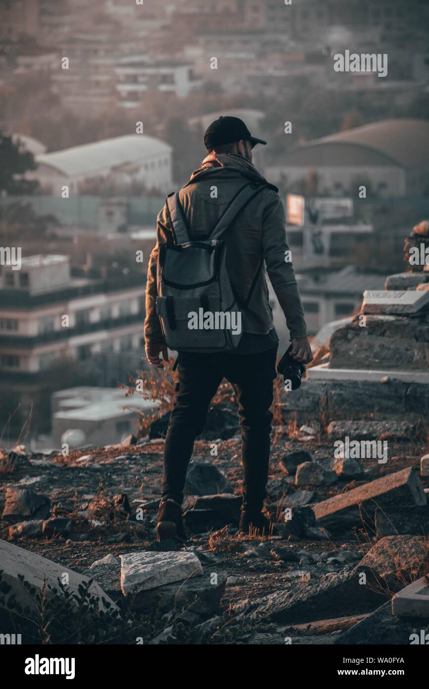 Male photographer walking on ruins of old stone architecture in the mountains Stock Photo