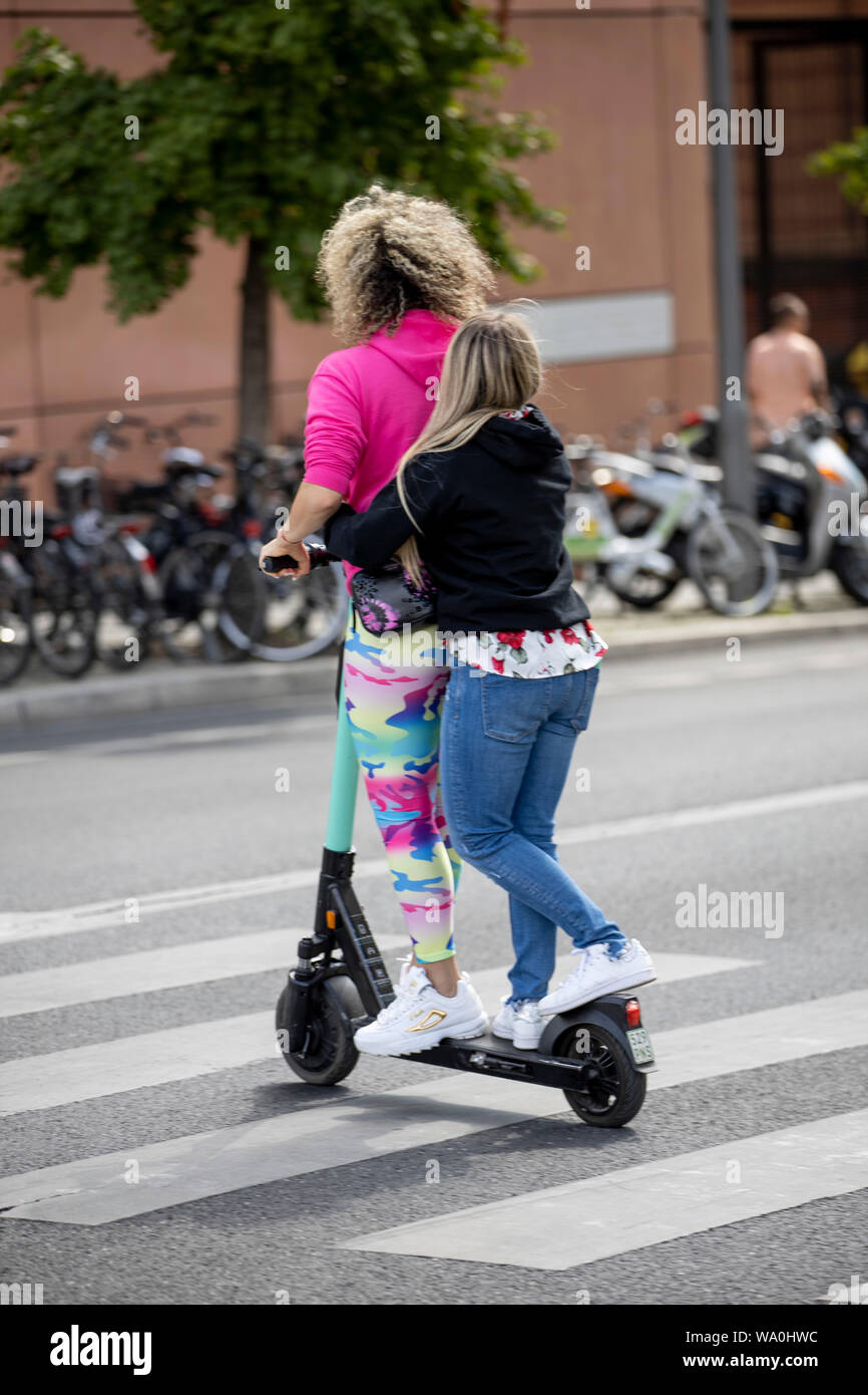 Two teenagers ride an electric scooter, escooter, escooter, on a