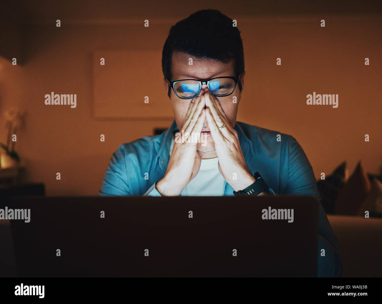 Man working late at night with a headache Stock Photo