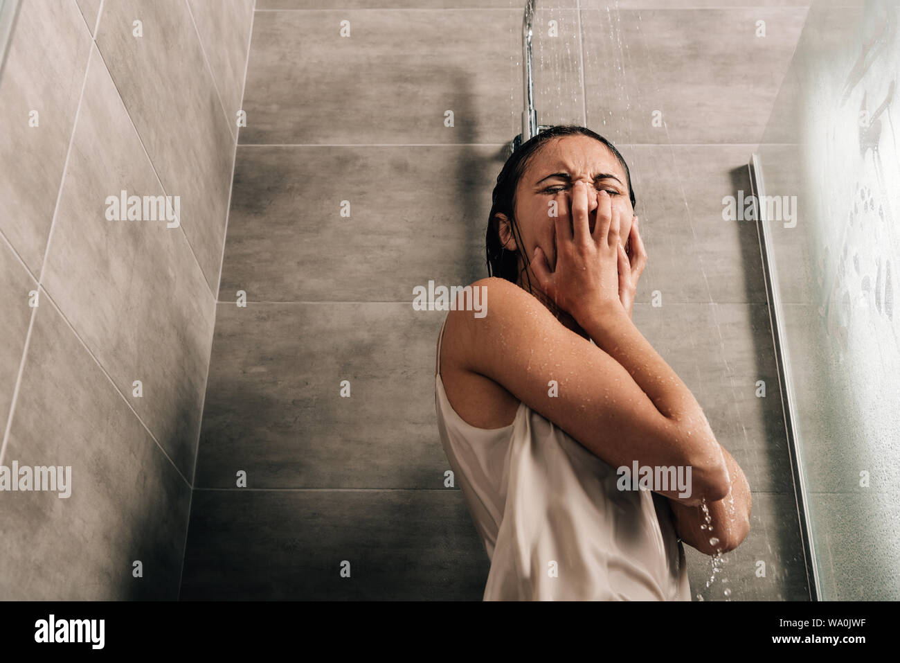 lonely sad woman crying in shower at home with copy space Stock Photo