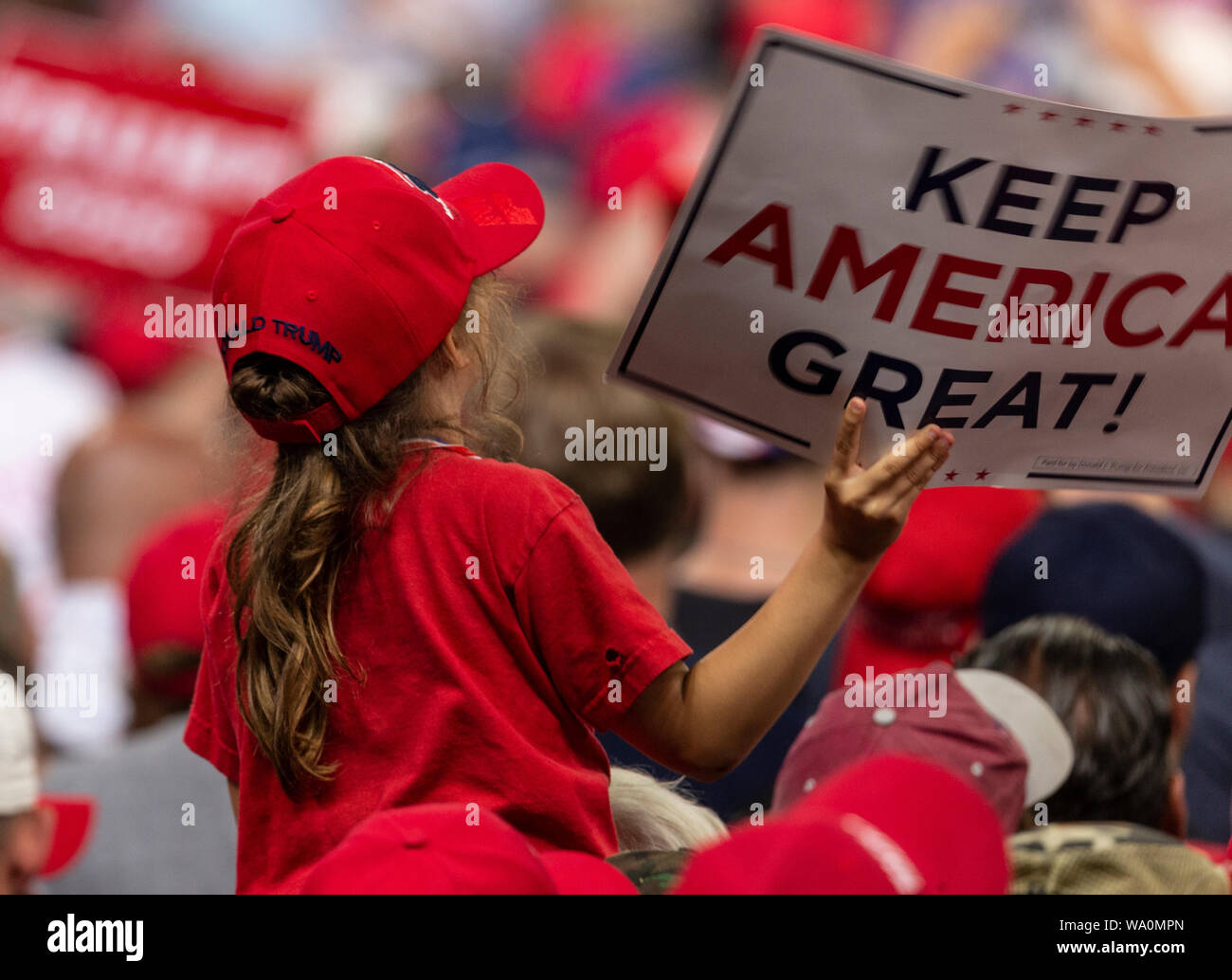 Manchester, NH - August 15, 2019: Young girl on shoulders of her father listens President Donald Trump speech at MAGA rally at Southern New Hampshire University Stock Photo