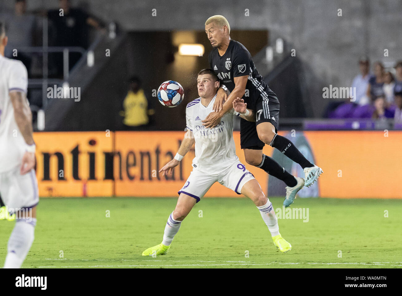 Orlando, Florida, U.S.A. 14th Aug, 2019. Orlando City forward CHRIS MUELLER (9) in action against Sporting Kansas City midfielder ROGER ESPINOZA (17) during the MLS game against Sporting Kansas City at Exploria Stadium in Orlando, Florida. Credit: Cory Knowlton/ZUMA Wire/Alamy Live News Stock Photo