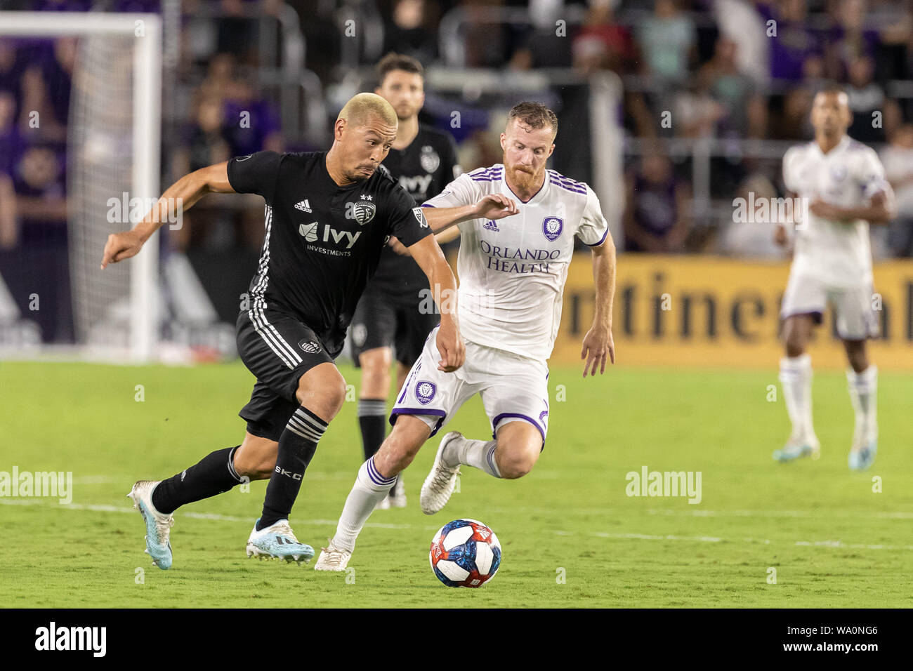 Orlando, Florida, U.S.A. 14th Aug, 2019. Sporting Kansas City midfielder ROGER ESPINOZA (17) competes for the ball against Orlando City midfielder ORIOL ROSWELL (20) during the MLS game at Exploria Stadium in Orlando, Florida. Credit: Cory Knowlton/ZUMA Wire/Alamy Live News Stock Photo
