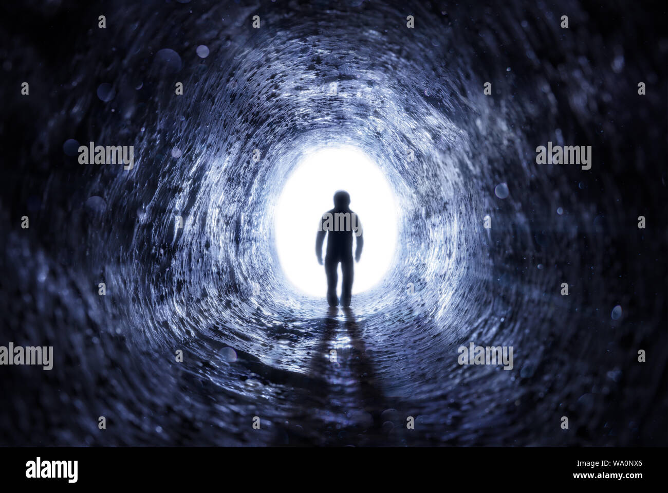 Senior Man Walking To The Light At The End Of The Tunnel - Hope After Life Stock Photo