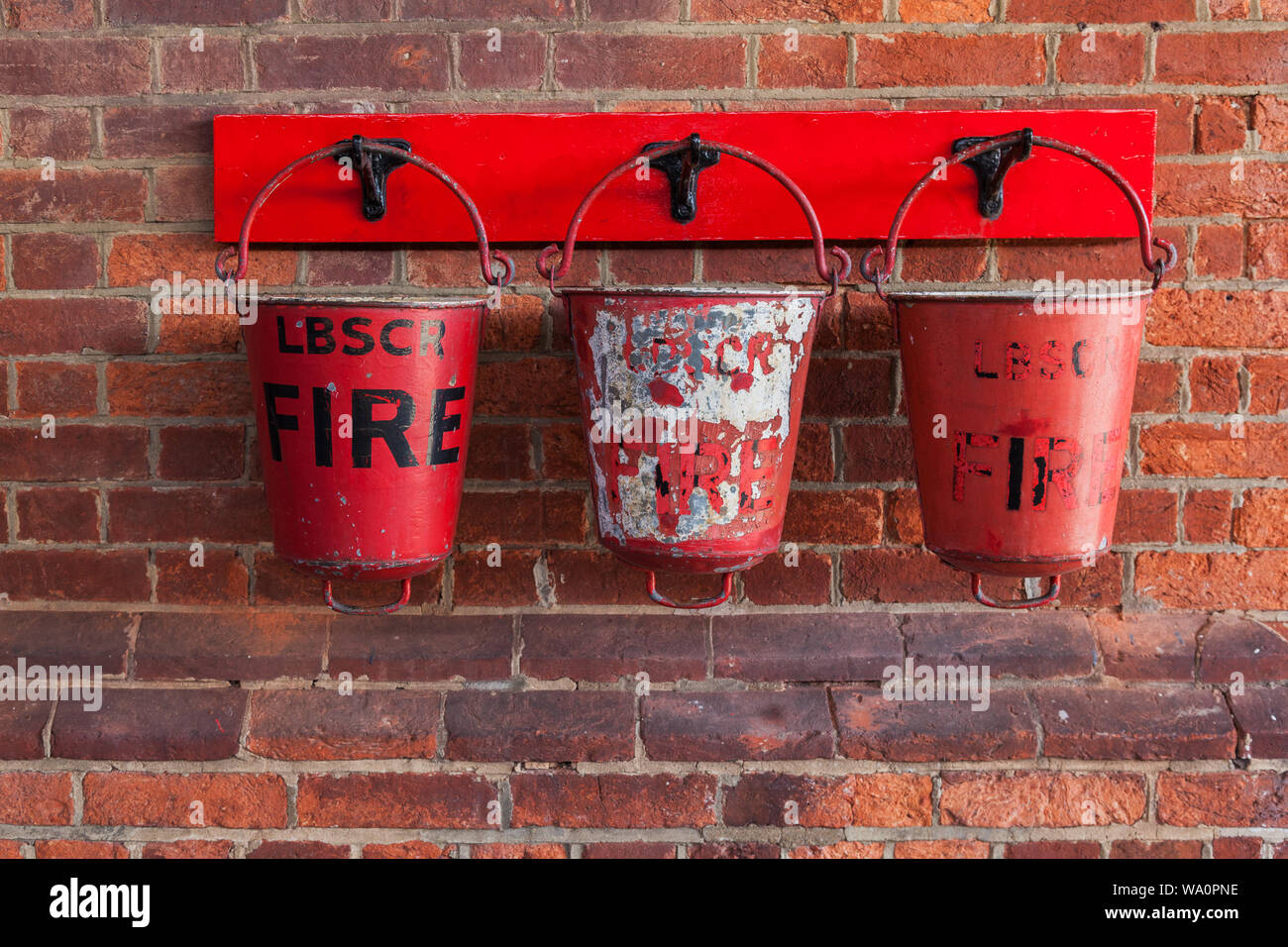Three fire buckets hanging on a railway station wall Stock Photo