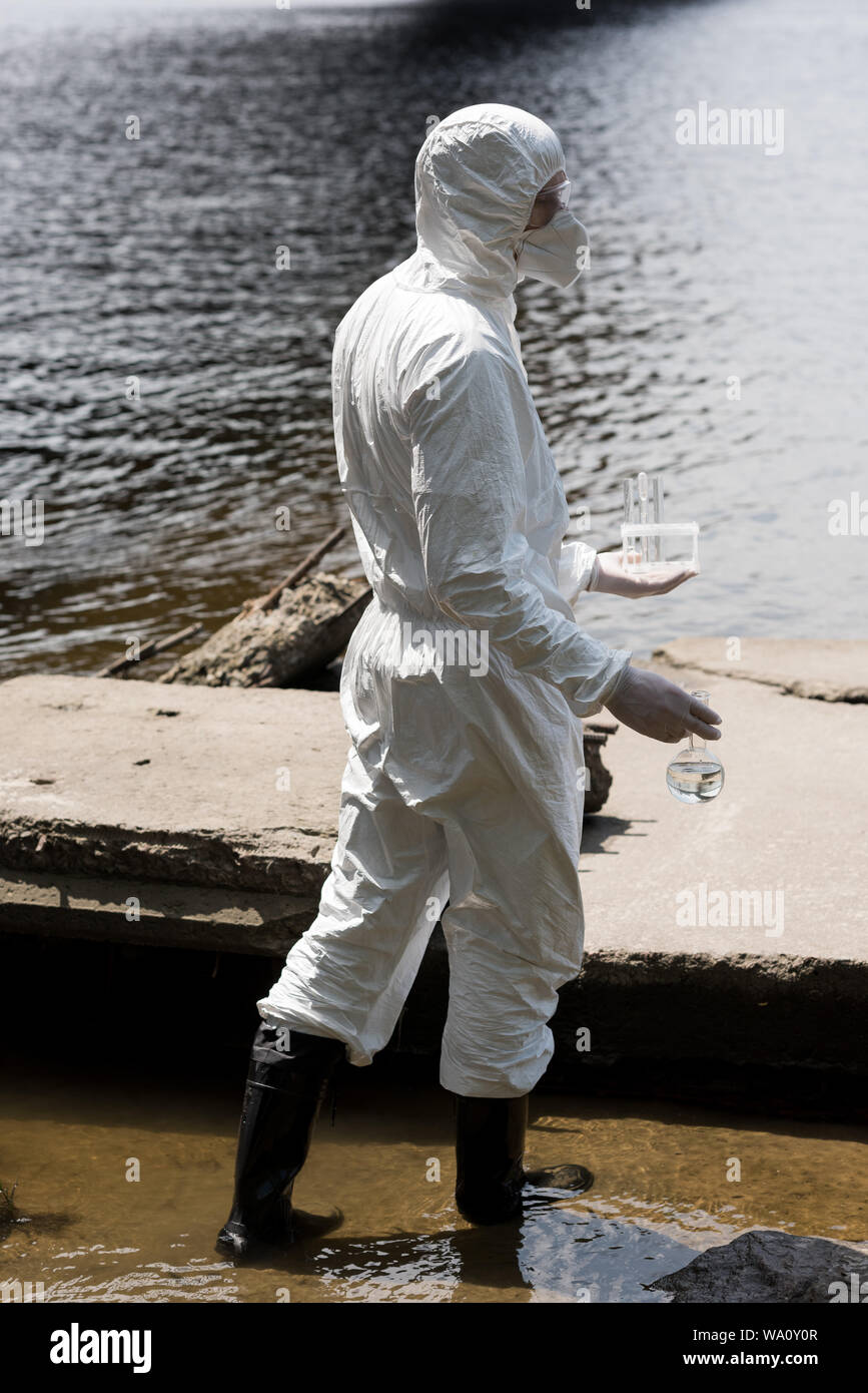 side view of water inspector in protective costume and respirator
