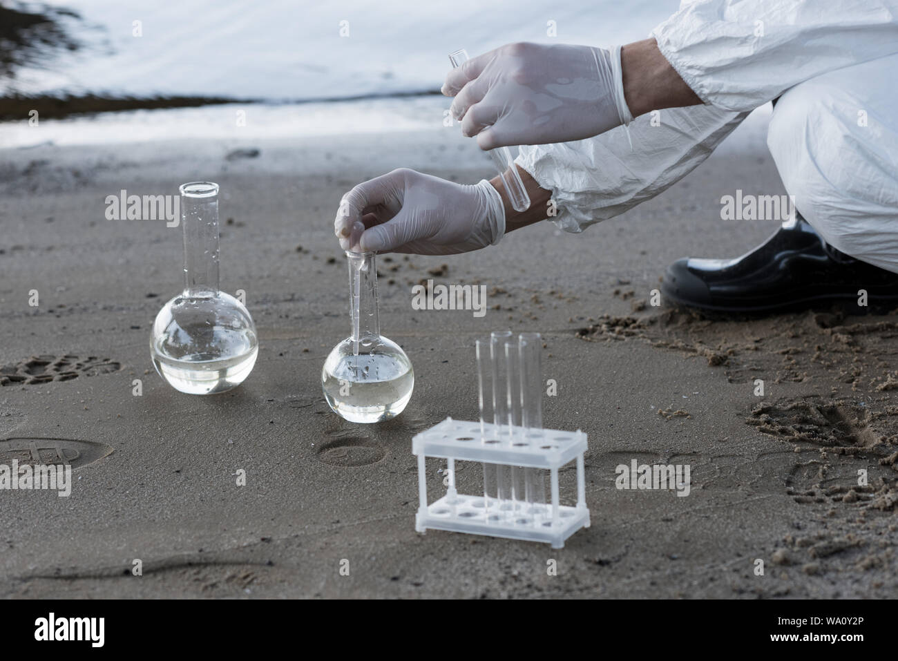 Water Inspector partial view of water inspector in latex gloves taking water samples at ...
