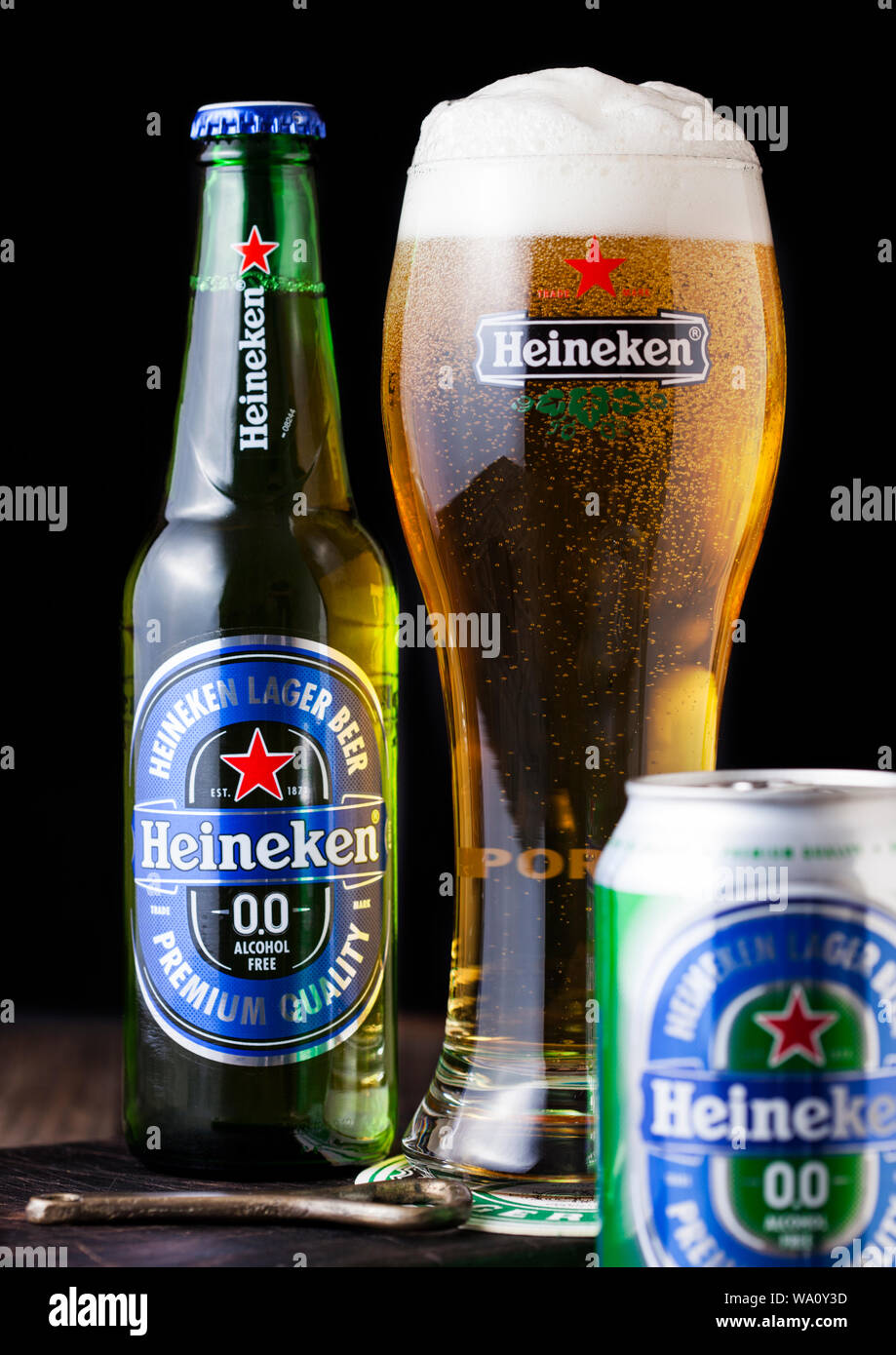 LONDON, UK - APRIL 27, 2018: Bottle and aluminium can of Heineken Alcohol free Lager Beer on dark wooden background. Heineken is the flagship product Stock Photo