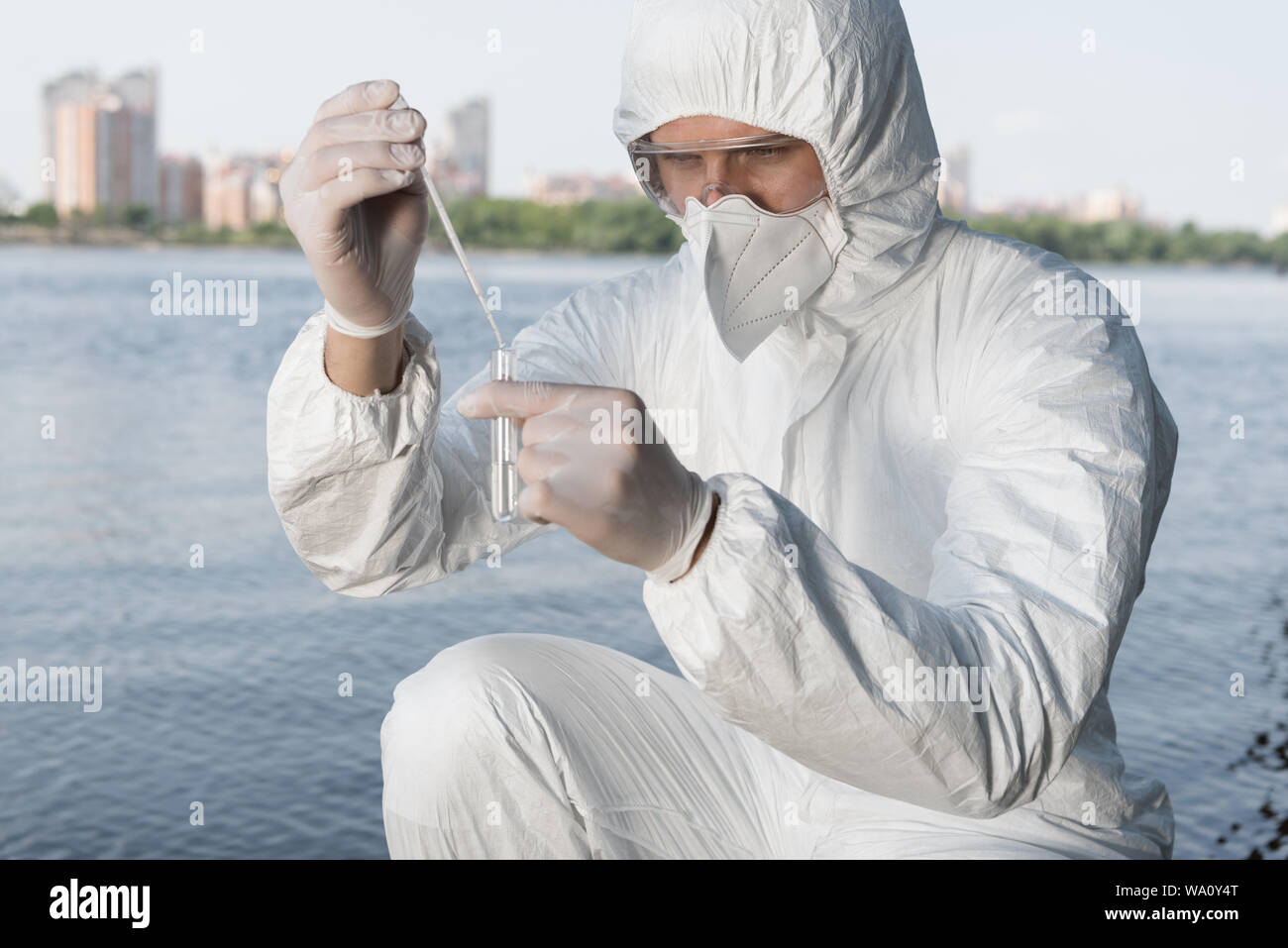Water Inspector water inspector in protective costume and respirator taking water ...
