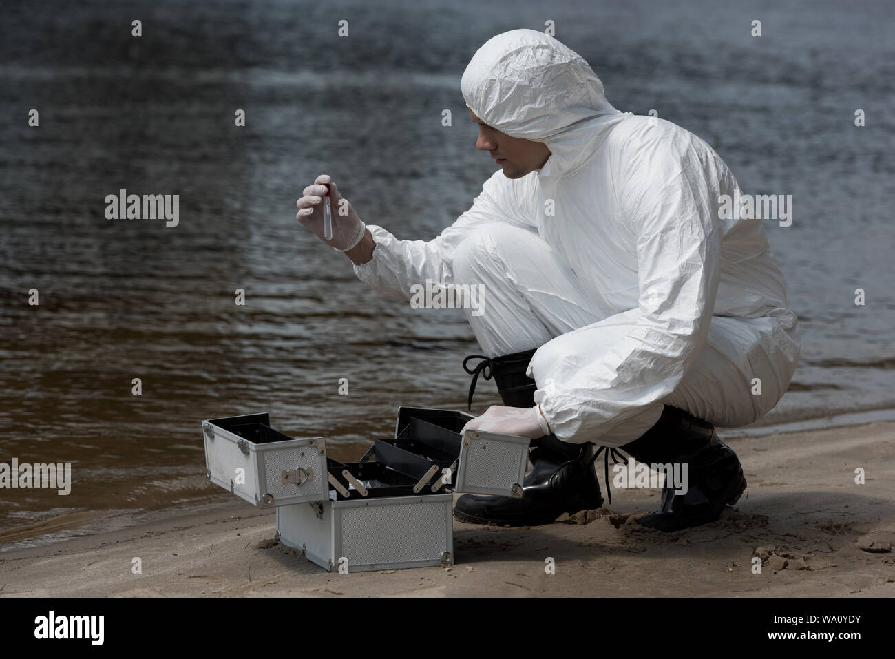 water inspector in latex gloves and protective costume opening