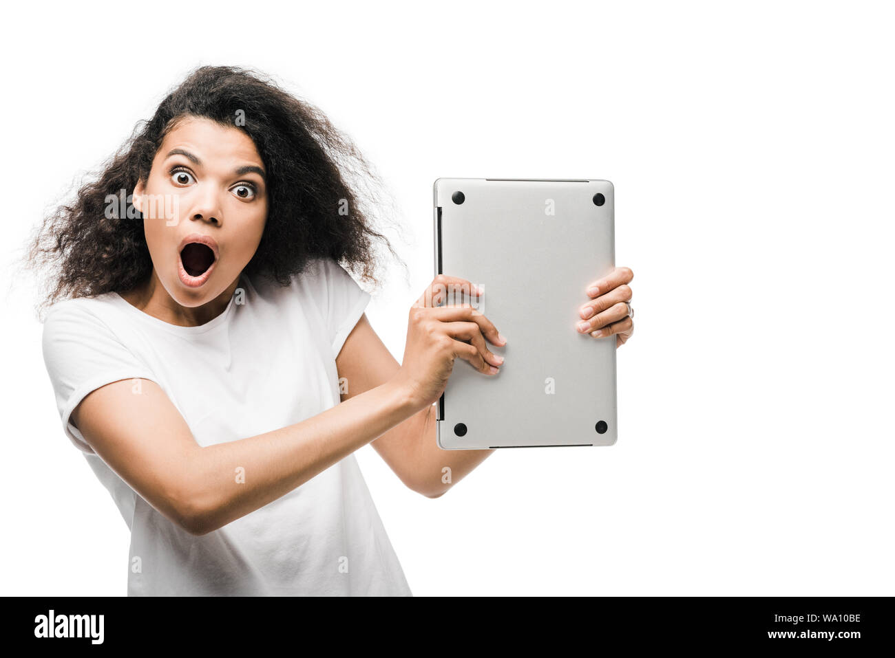 surprised curly african american woman holding laptop isolated on white Stock Photo