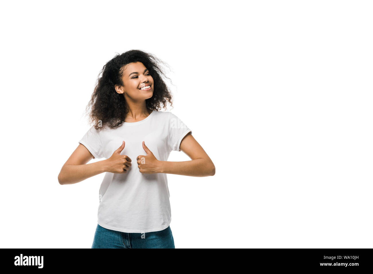 curly and positive african american woman showing thumbs up isolated on ...