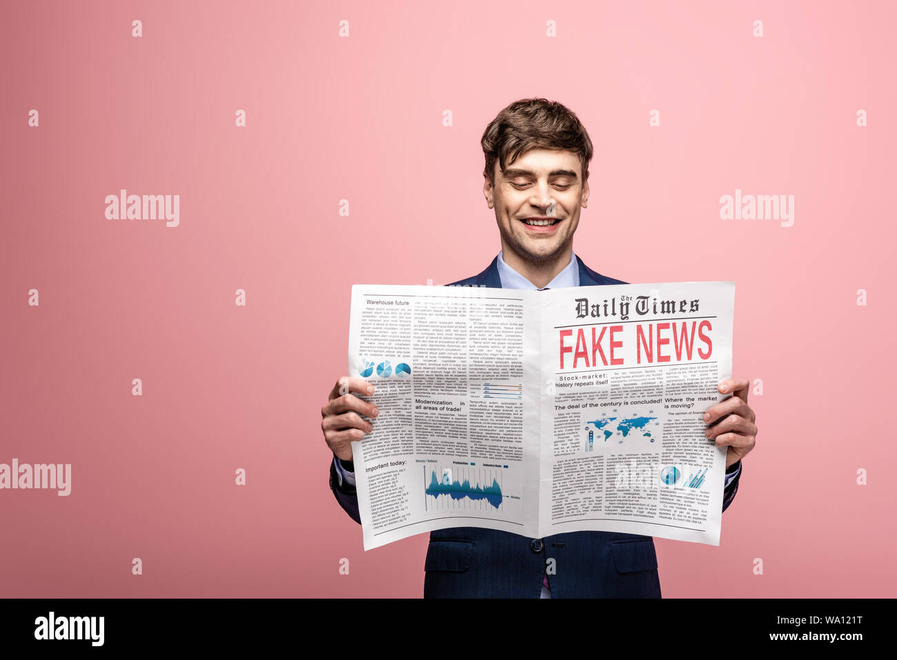 cheerful businessman reading newspaper with fake news and smiling on ...