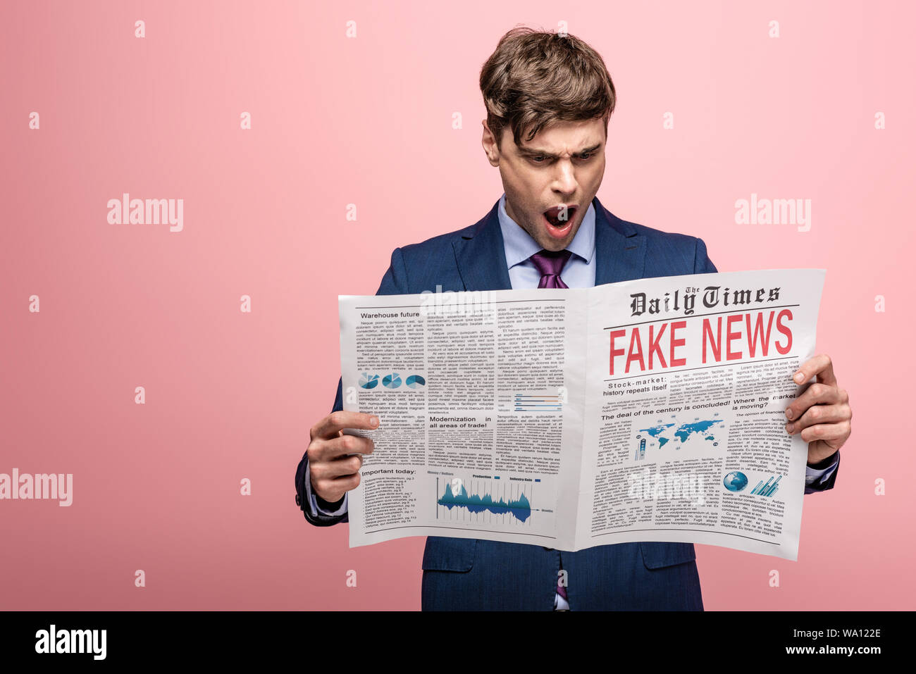 shocked businessman reading newspaper with fake news on pink background ...