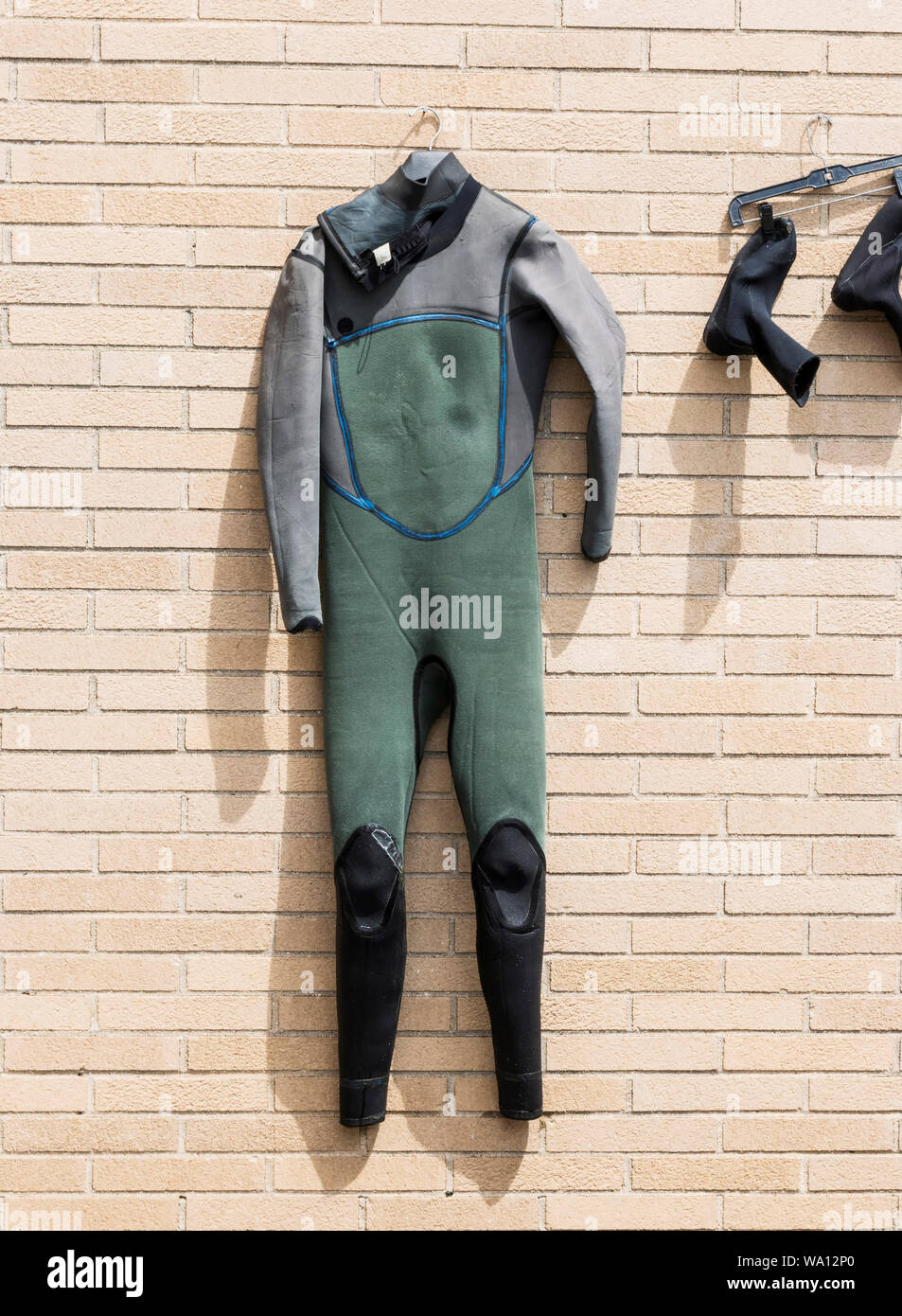 A surfer has his wet suite hanging outside his office drying in the
