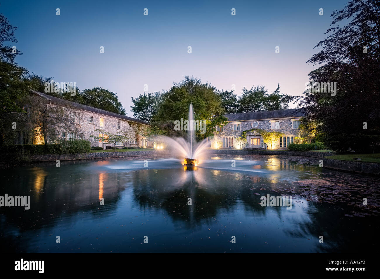 Cliff at Lyons, Celbridge, Kildare, Ireland - 13th May 2019. Dusk falls on the water fountain and lake at Cliff at Lyons hotel in Kildare in Northern Stock Photo