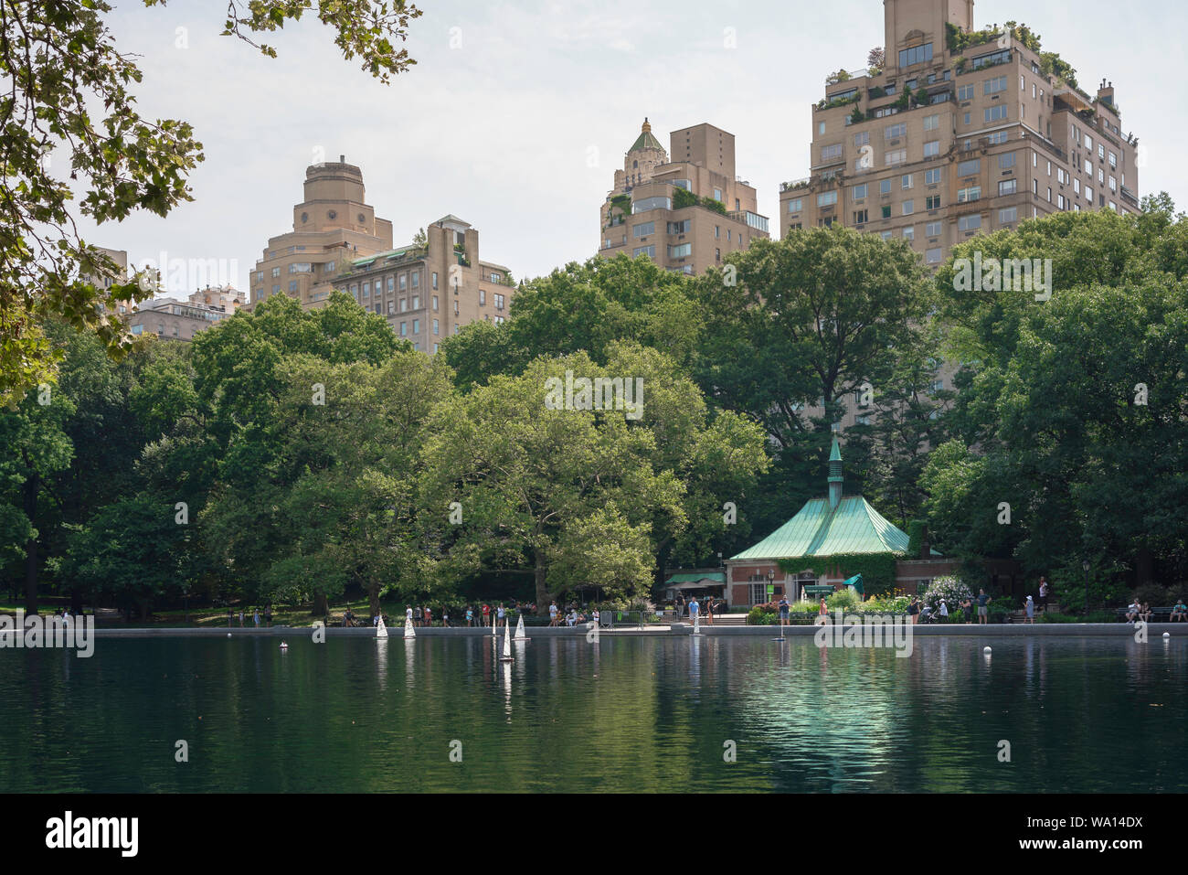 View in summer of the Conservatory Water model boat lake in East Central Park and Upper East Side buildings in Manhattan, New York City, USA Stock Photo