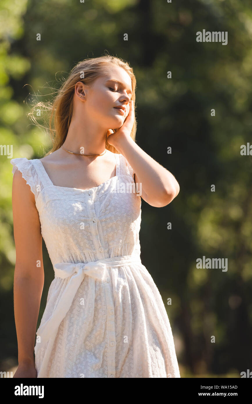 beautiful girl in white dress standing on meadow with closed eyes Stock ...