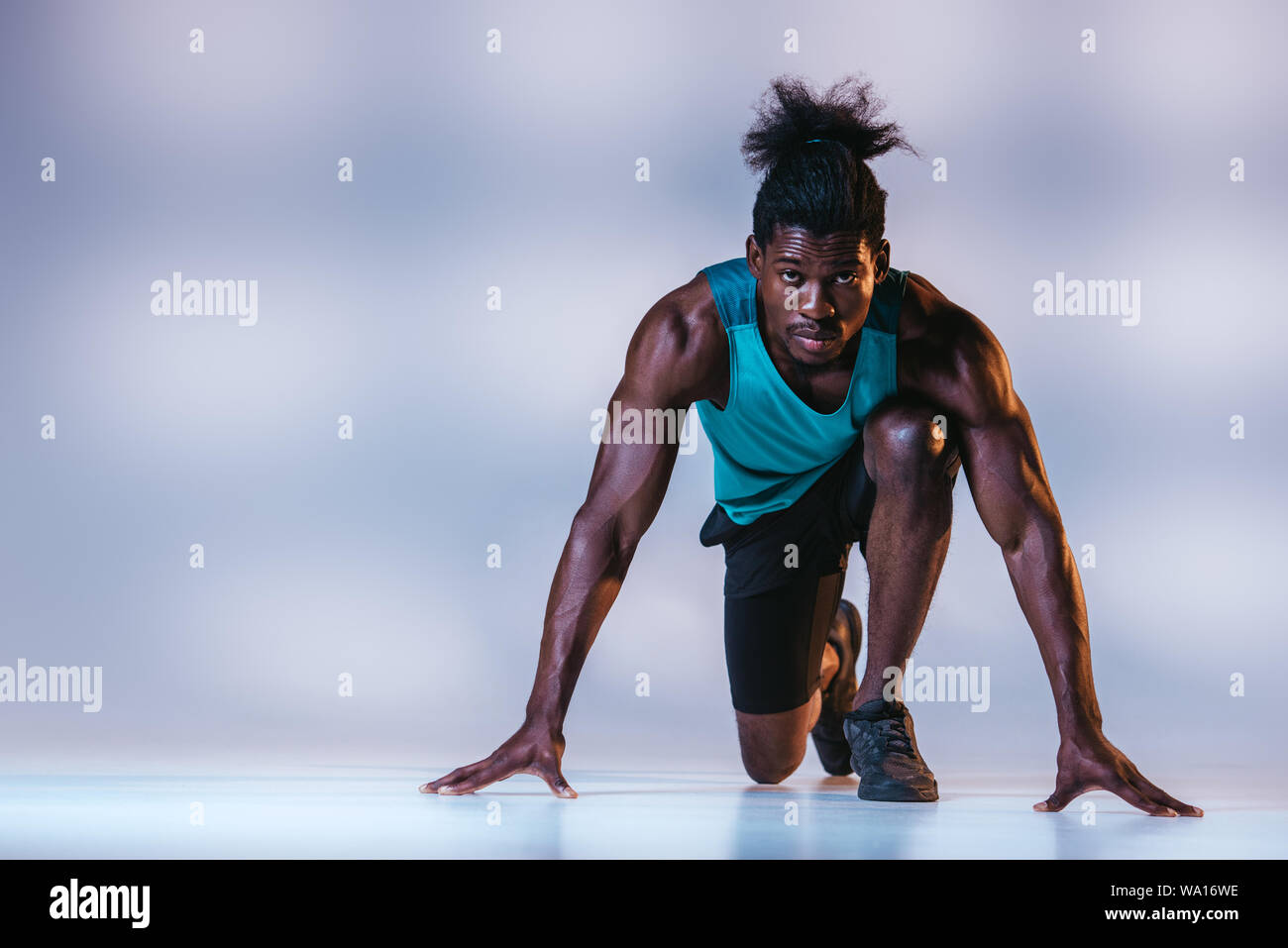 african american sportsman standing in start position and looking at ...