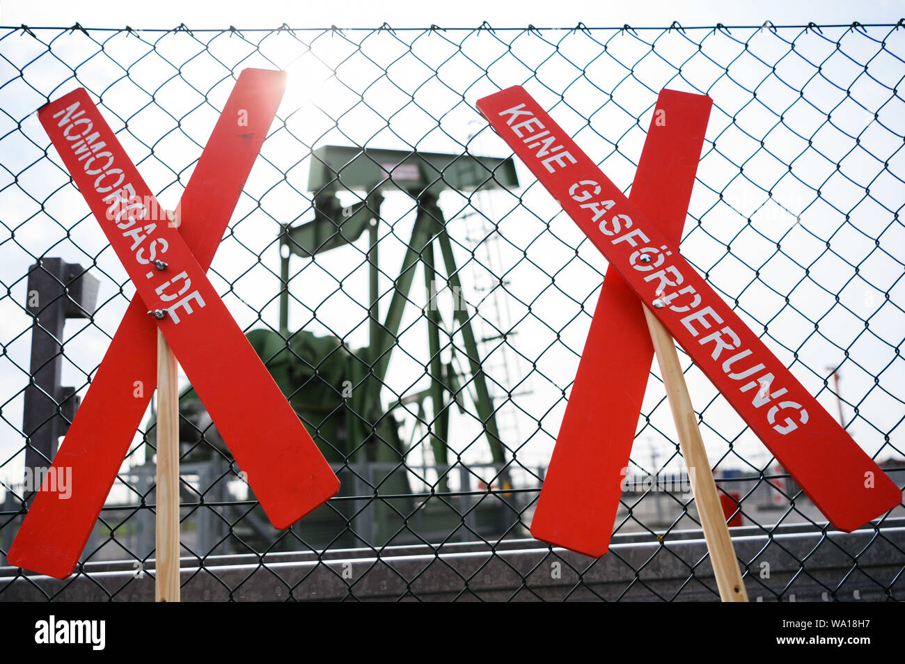 Emlichheim, Germany. 16th Aug, 2019. Crosses of the citizens' initiative 'NoMoorGas - No natural gas production in our region' are leaned against a fence in front of Wintershall Dea's oil field. At the oil field in Emlichheim on the Dutch border, reservoir water may have escaped unnoticed for several years since 2014 during a press-in well. Experts speak of up to 220 million litres. Credit: Mohssen Assanimoghaddam/dpa/Alamy Live News Stock Photo