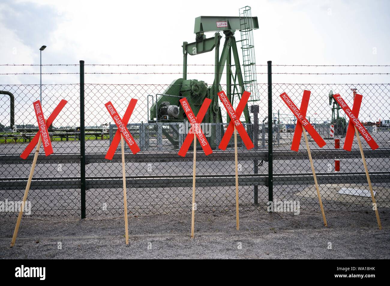 Emlichheim, Germany. 16th Aug, 2019. Crosses of the citizens' initiative 'NoMoorGas - No natural gas production in our region' are leaned against a fence in front of Wintershall Dea's oil field. At the oil field in Emlichheim on the Dutch border, reservoir water may have escaped unnoticed for several years since 2014 during a press-in well. Experts speak of up to 220 million litres. Credit: Mohssen Assanimoghaddam/dpa/Alamy Live News Stock Photo