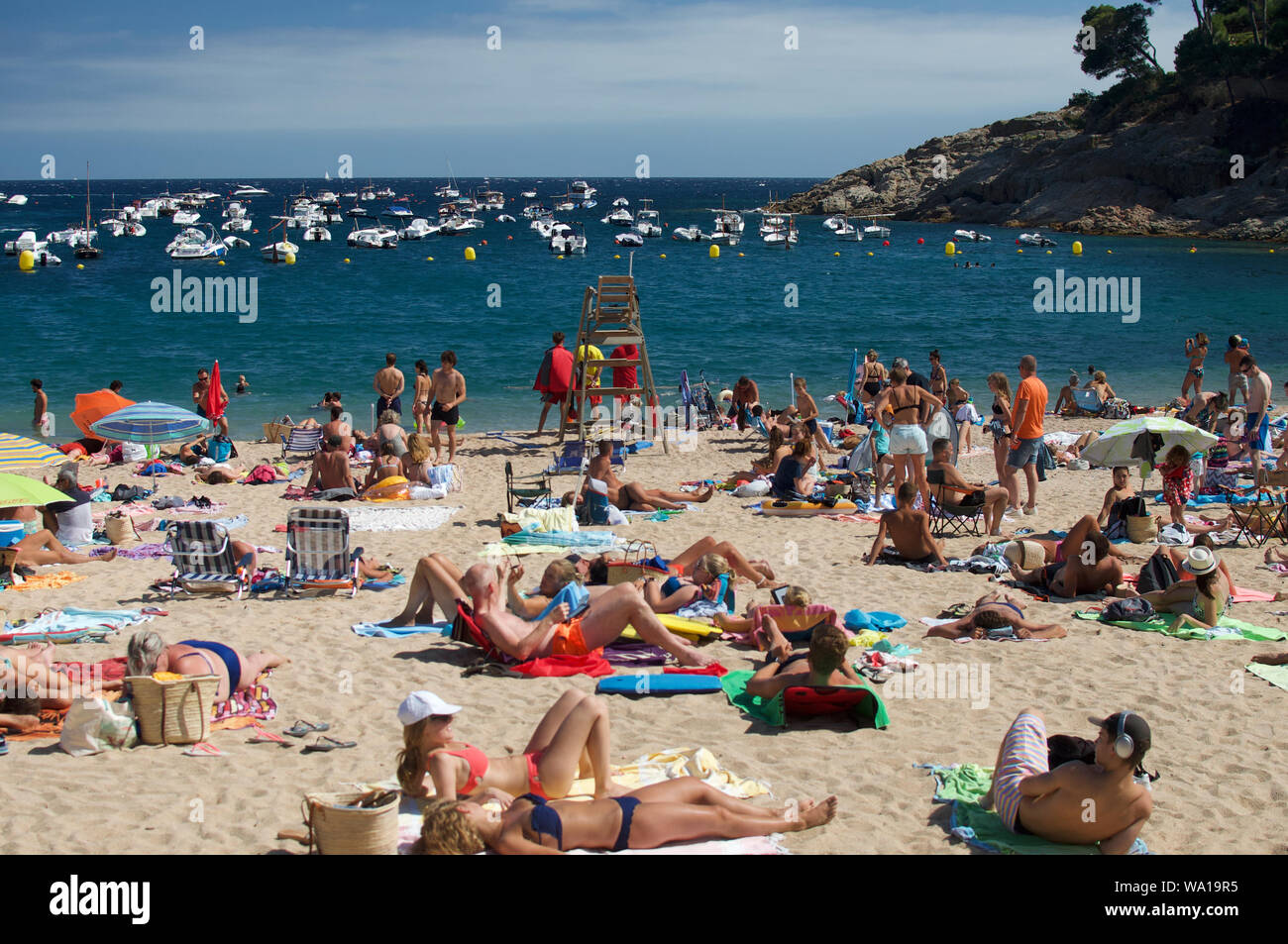 Crowded Costa Brava beach drink summer at Tamariu, Catalunya, Spain Stock Photo