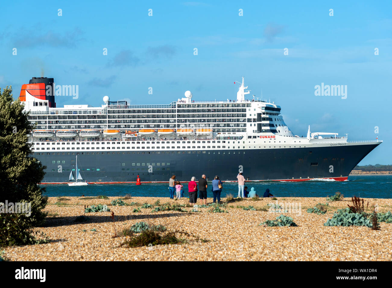 Queen Mary 2, the famous ocean liner, departing on a cruise from Southampton and sailing along The Solent on a summer afternoon.Hampshire,England,UK Stock Photo