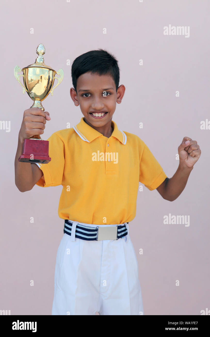 Schoolboy showing a trophy and smiling Stock Photo
