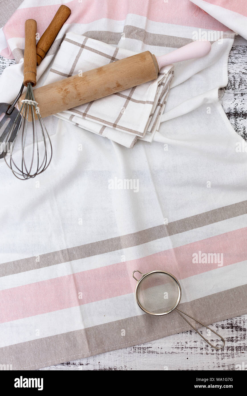Old vintage kitchen utensils, cotton dishcloth on old white wooden background. Selective focus. Stock Photo