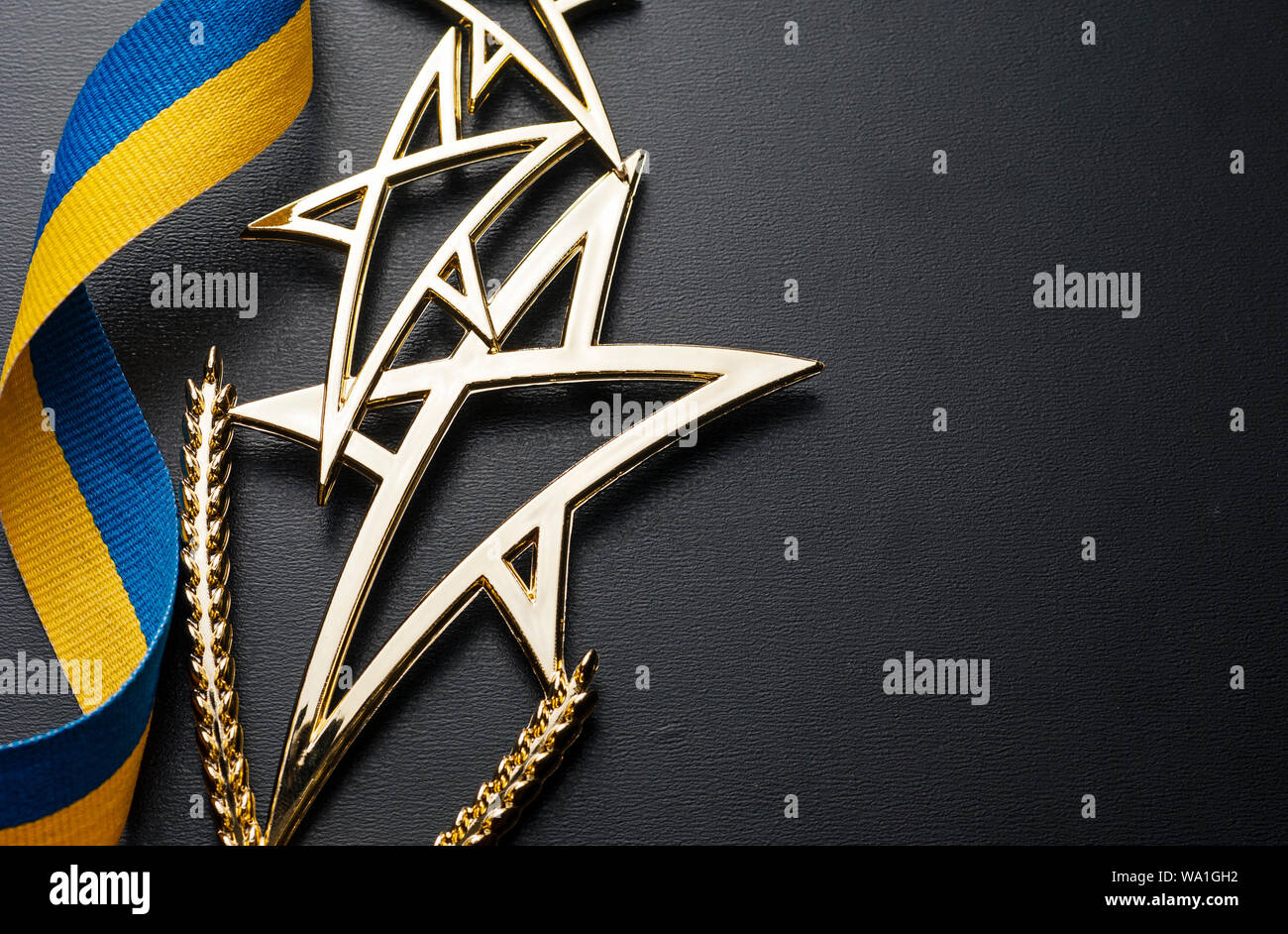 Gold Shooting Star Trophy For A Competition Winner Or Champion With Twirled Blue And Yellow Ribbon Over Grey With Copy Space Stock Photo Alamy