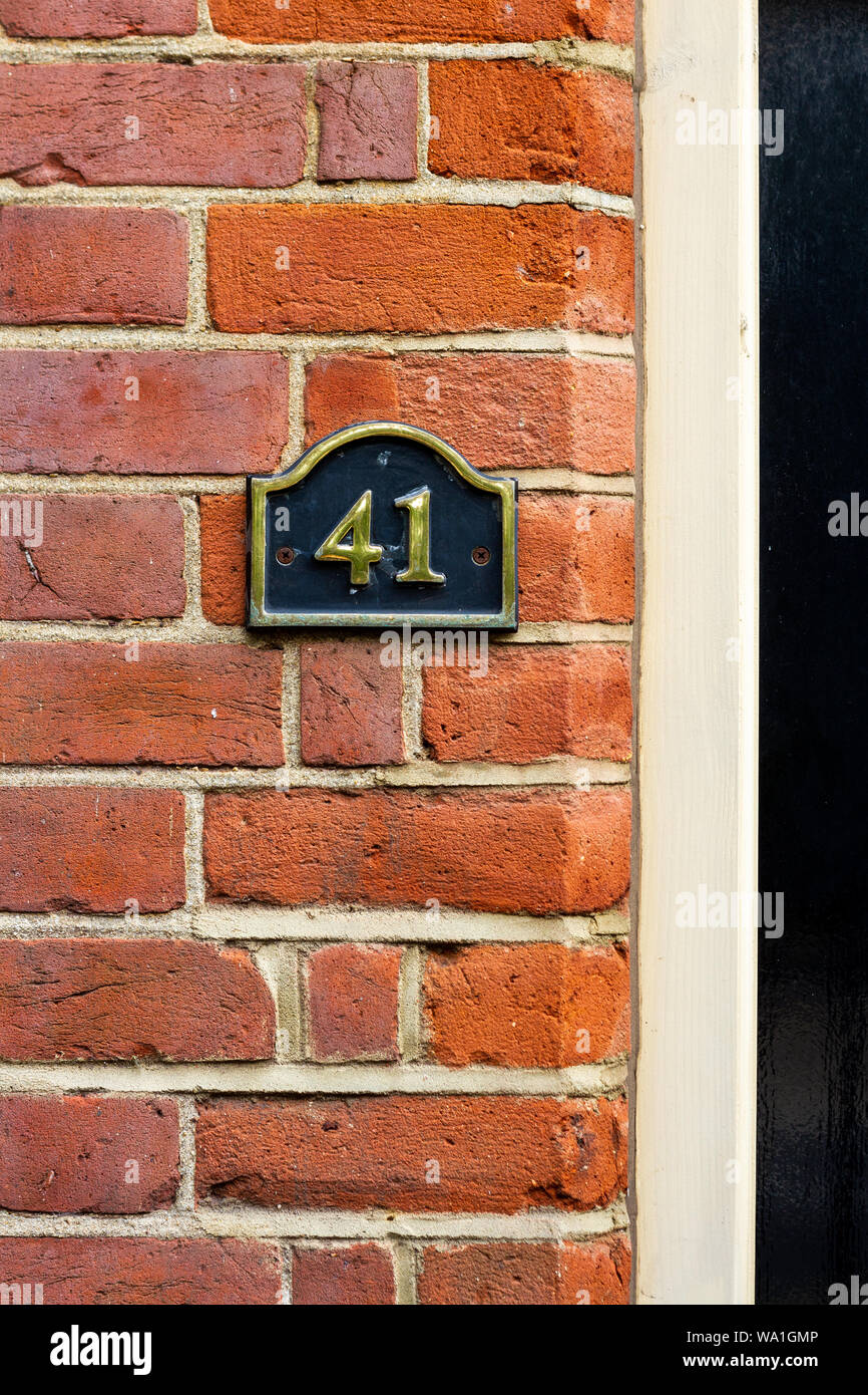 House number 41 on a black metal sign on a red brick wall Stock Photo