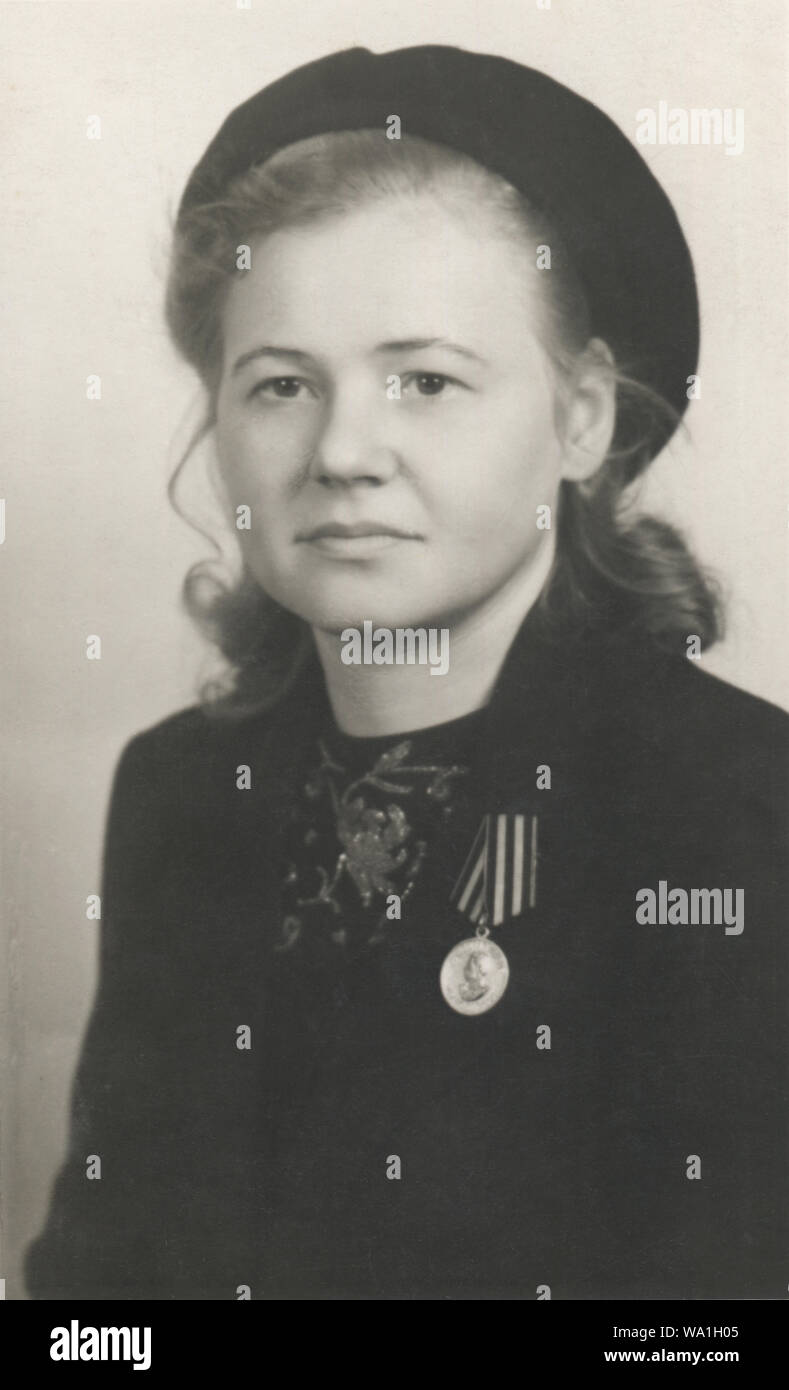 Vintage portrait of young woman with a medal 'For the Victory over Germany in the Great Patriotic War 1941–1945', Germany, 1945 Stock Photo
