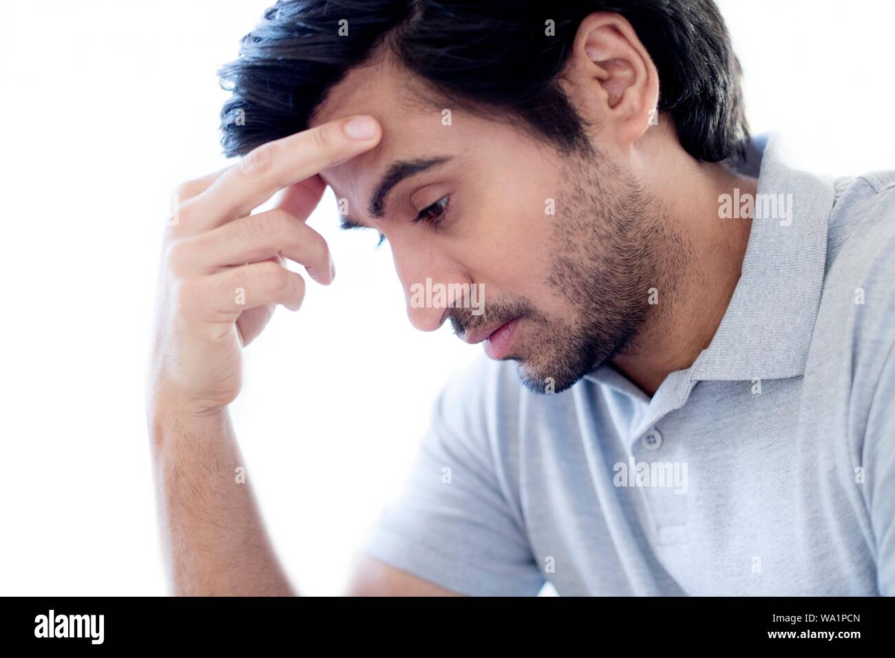 Man touching his forehead. Stock Photo