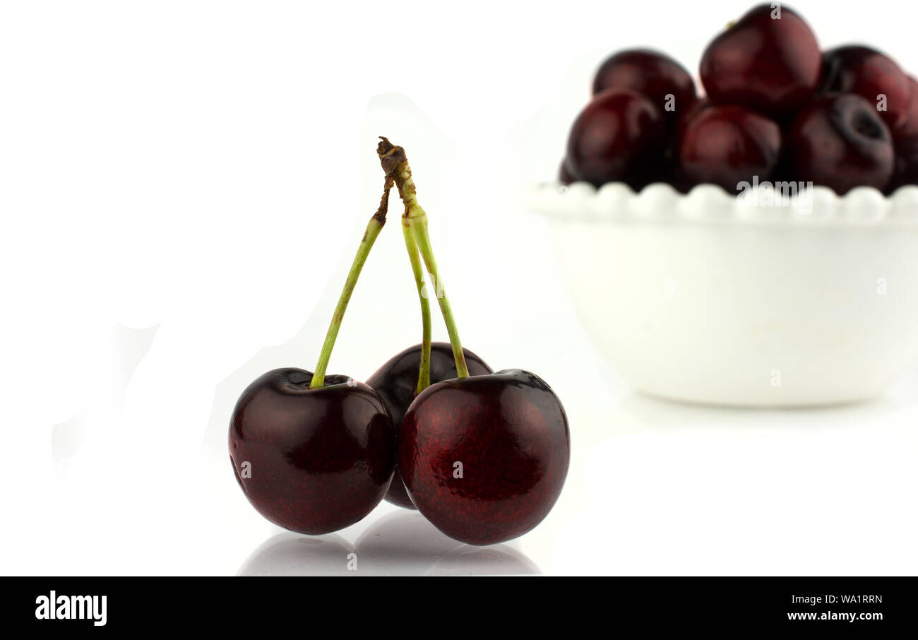 close-up some cherries with stems. Isolated on white background. Stock Photo