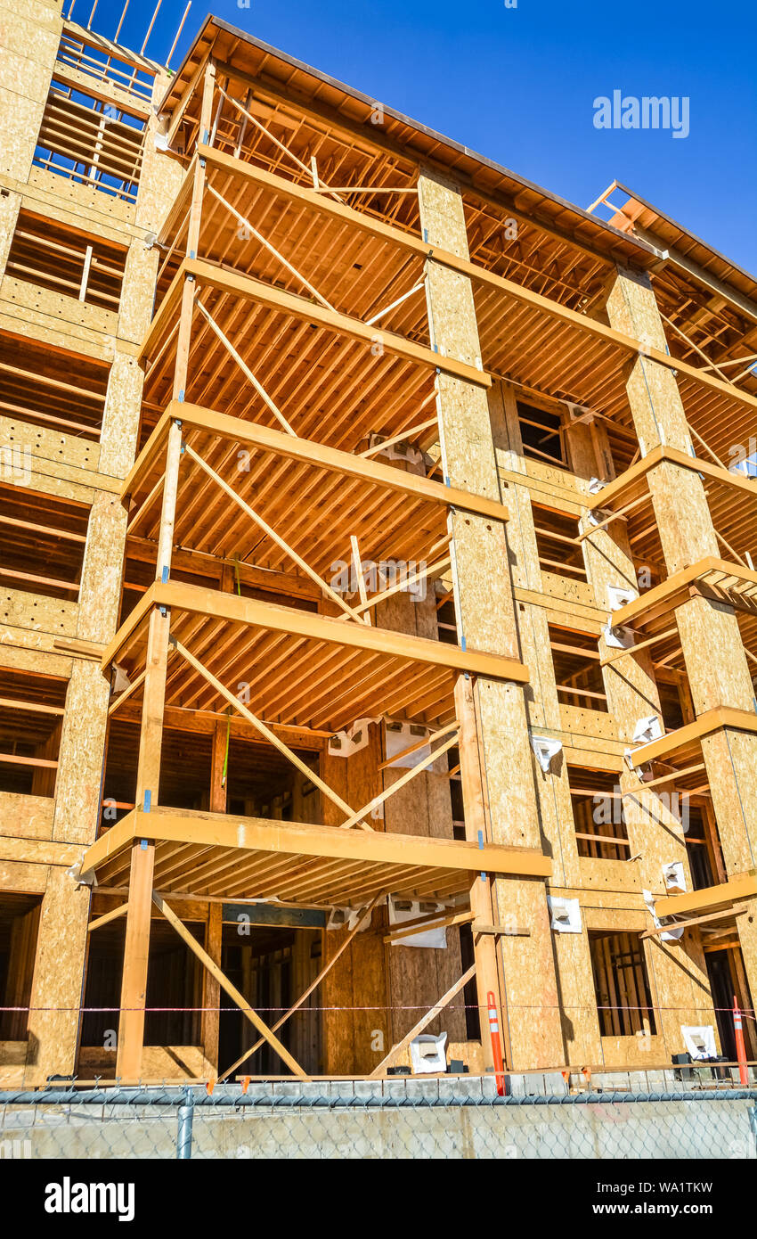 Six storey frame building under construction on concrete foundation bed. Stock Photo