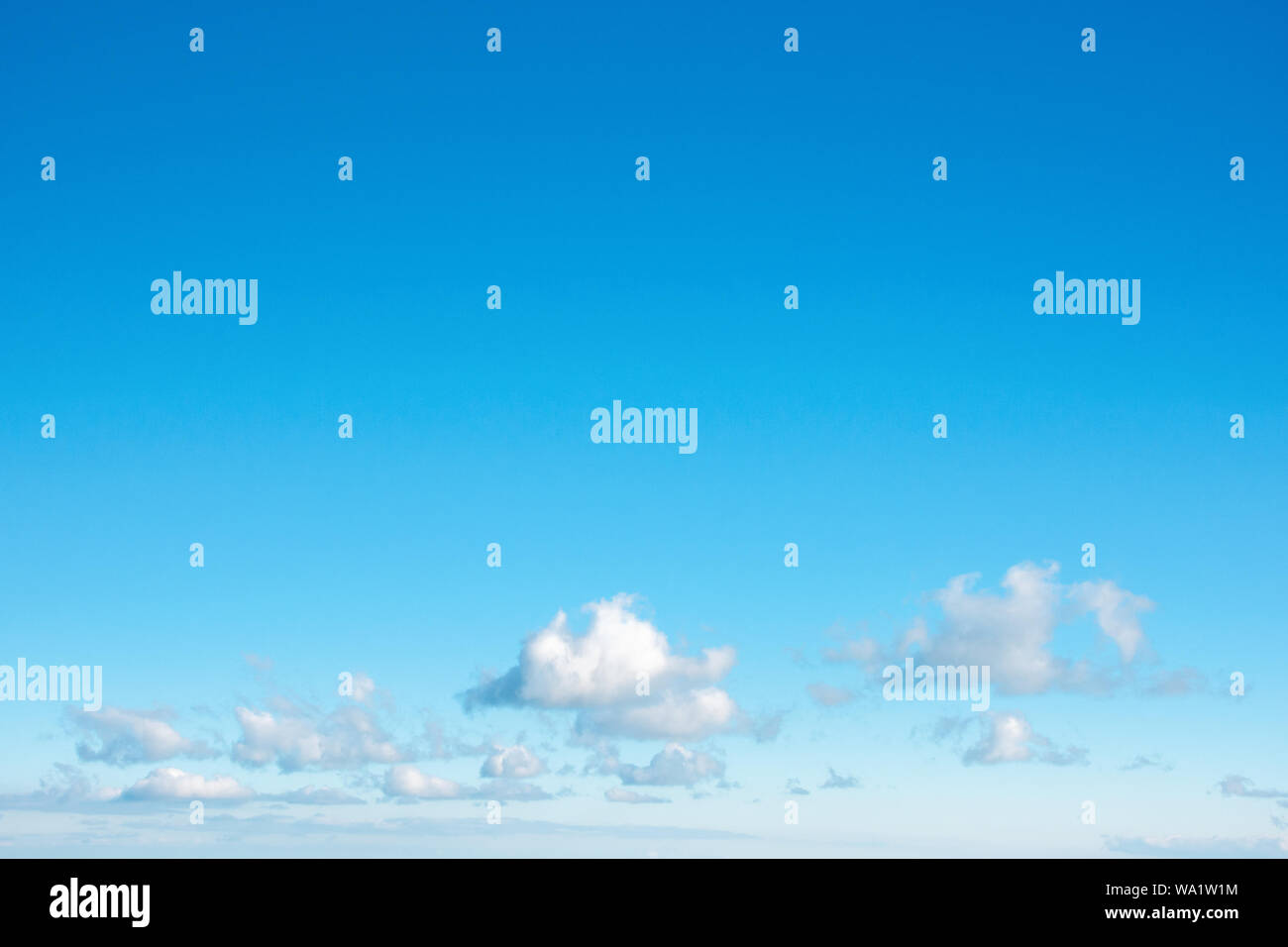 fleecy clouds on an azure sky. beautiful nature background. dynamic side lit cloudscape Stock Photo