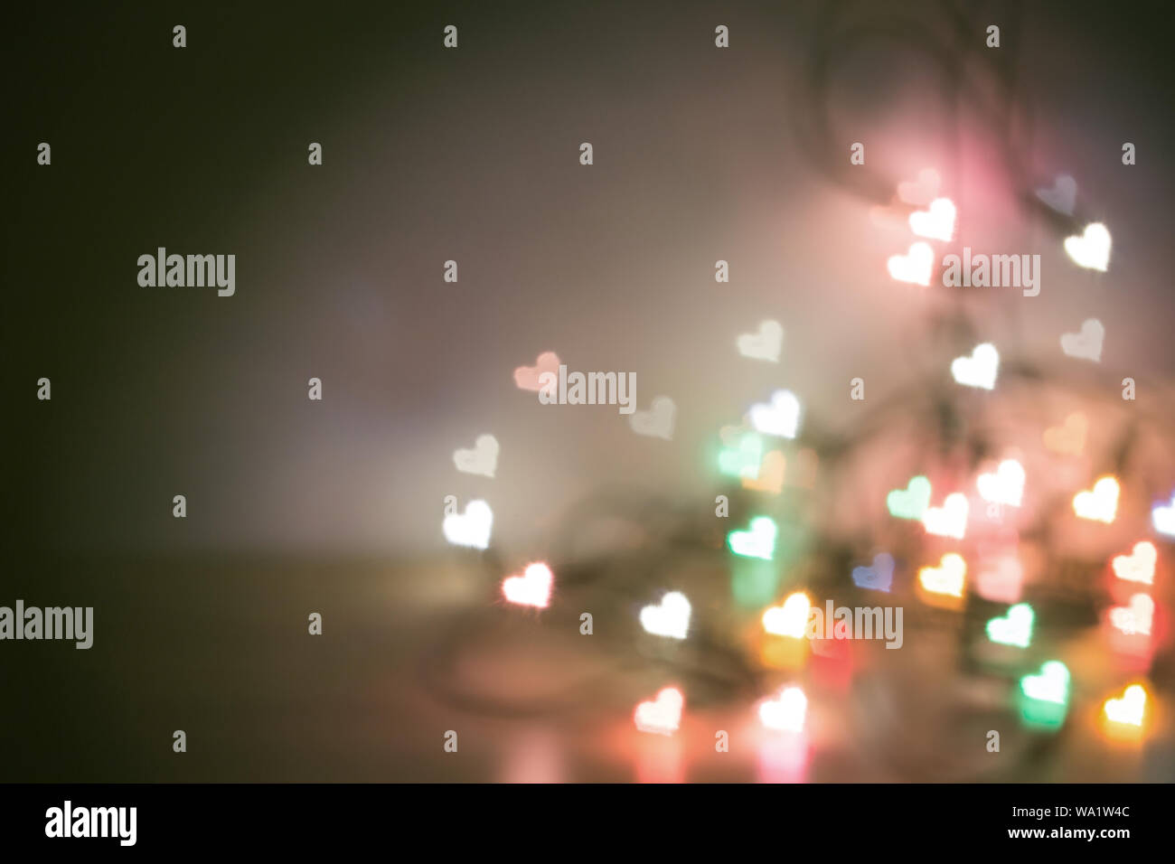Blur christmas lights with bokeh heart shape light low depth of focus with copy space in concept vintage tone style. Stock Photo