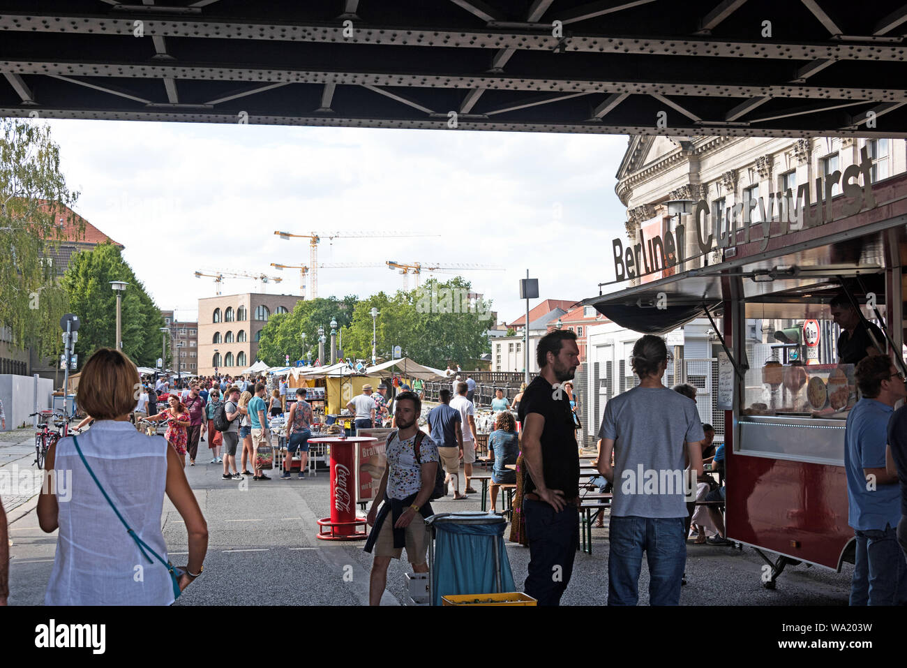 Shoppers at a Currywurst stall under the Stadtbahn Bridge at the Antique and Book Market near the Bode Museum, Berlin, Germany. Stock Photo