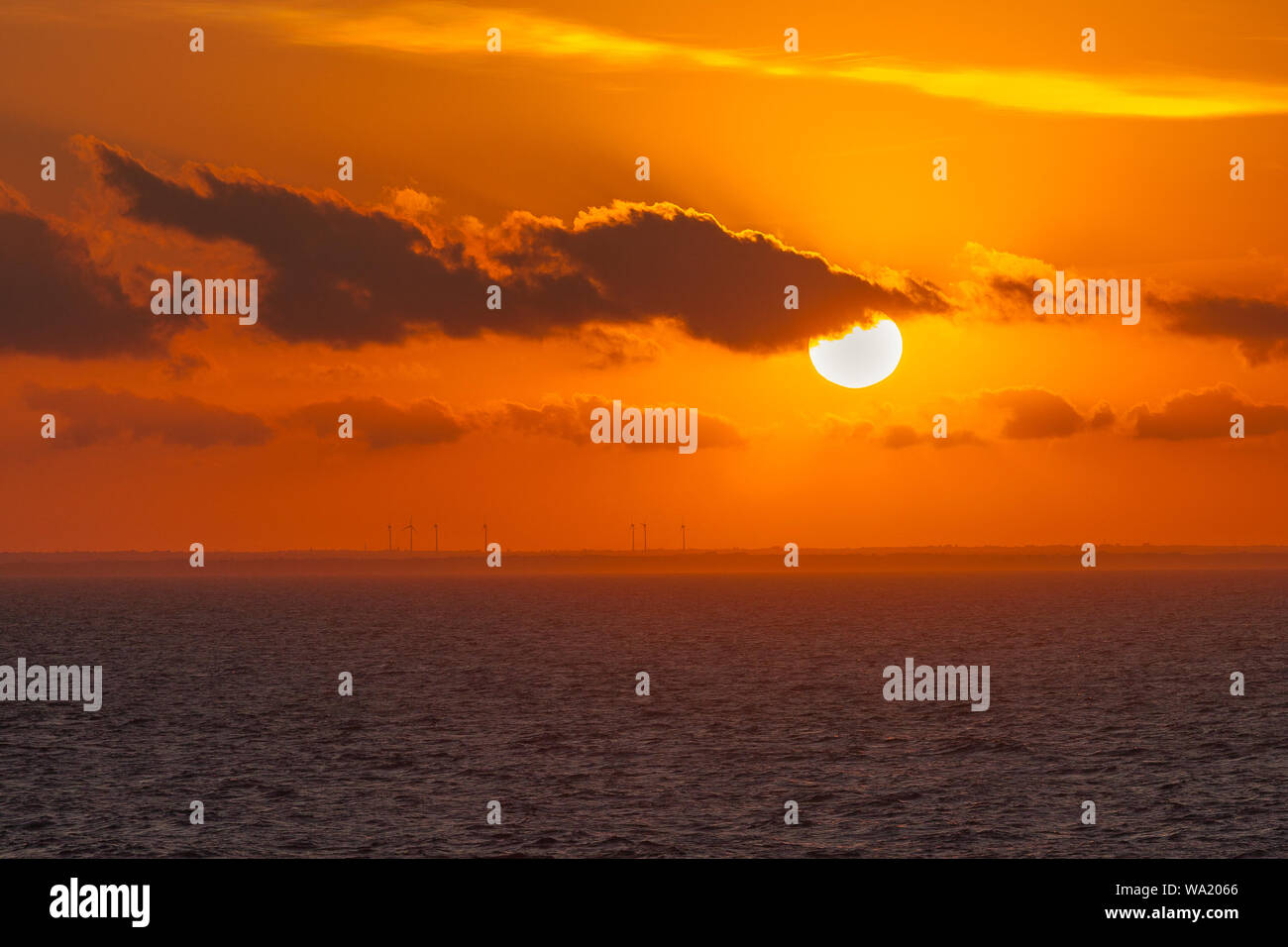 Wind turbines on the Italian coast during a dreamy sunset, Puglia, Italy Stock Photo