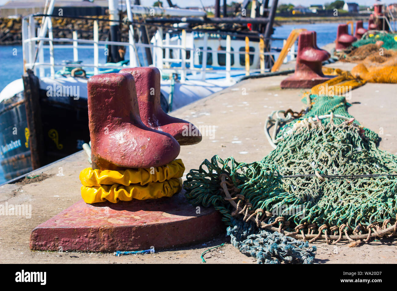 A iron cast mooring bollard and fishing nets on the quayside at Ardglass Harbour Northern Ireland Stock Photo