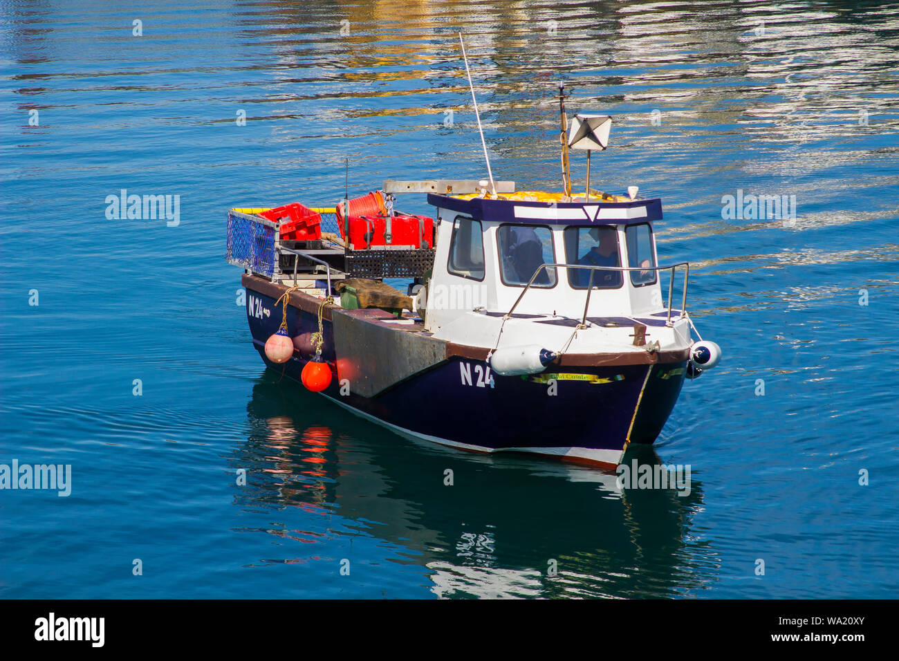 8 August 2019 A small boat used for lobster and crab fishing coming to discharge her catch in Ardglass Harbour County Down Northern Ireland on a fine Stock Photo
