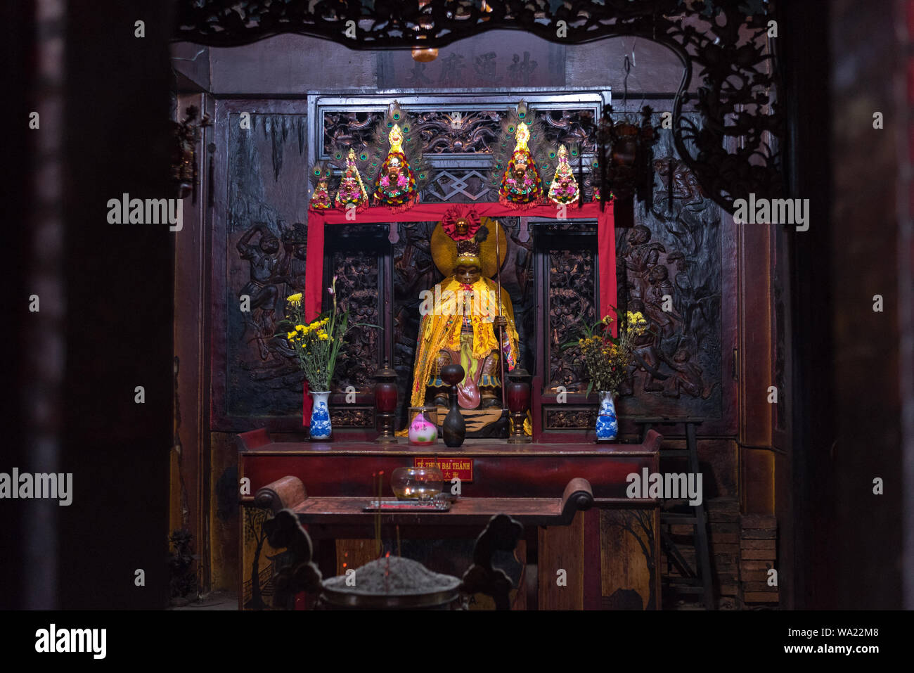 Ho Chi Minh City, Vietnam: an altar of Ha Chuong Hoi Quan pagoda with a statue of Hanuman and wooden carving depicting army of monkeys. Stock Photo