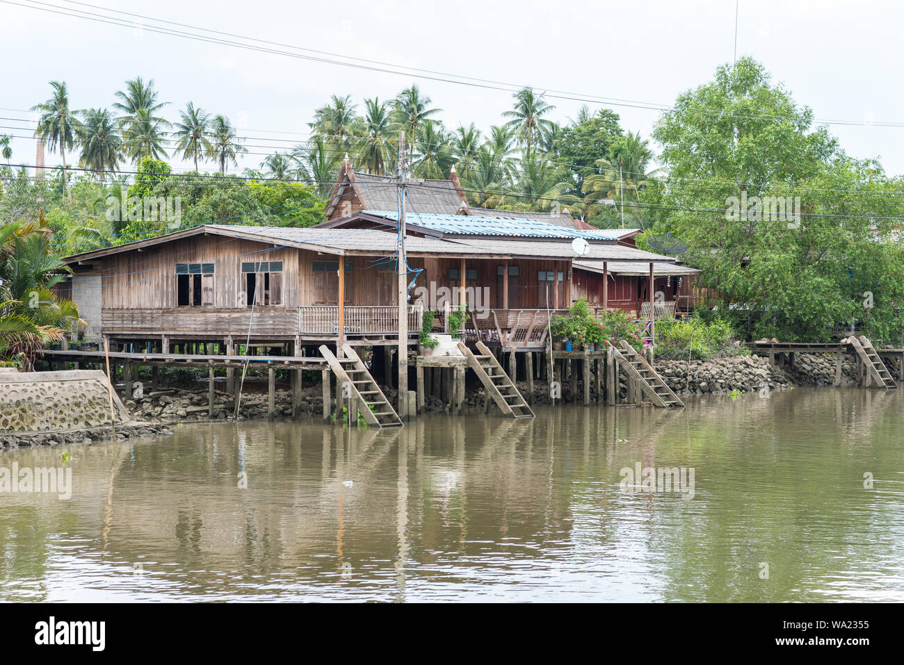 Wooden stilt house beside a canal in Samut Songkhram province, Thailand. At a boat tour from Amphawa Floating Market. Stock Photo