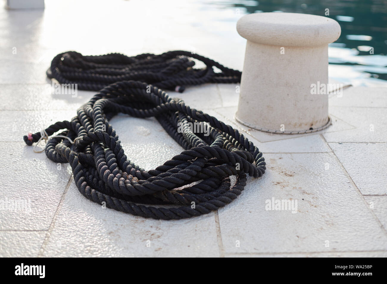 Ship's rope lying on the quay Stock Photo