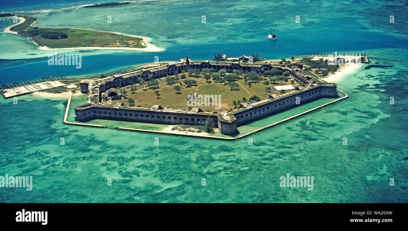 This aerial photograph shows Fort Jefferson, a huge coastal fortification built from 1846-1876 with 16 million handmade bricks on a shallow island of the Dry Tortugas, which are outermost of the Florida Keys in Florida, USA. Located 68 miles (109 kilometers) west of the Key West, the historic six-sided structure covers 11 acres (4.5 hectares) and is considered the largest brick building in the Western Hemisphere. The openings in its walls were gun ports for cannons that once protected American shipping in the Atlantic Ocean and Gulf of Mexico. The fort is now a U.S. National Monument. Stock Photo