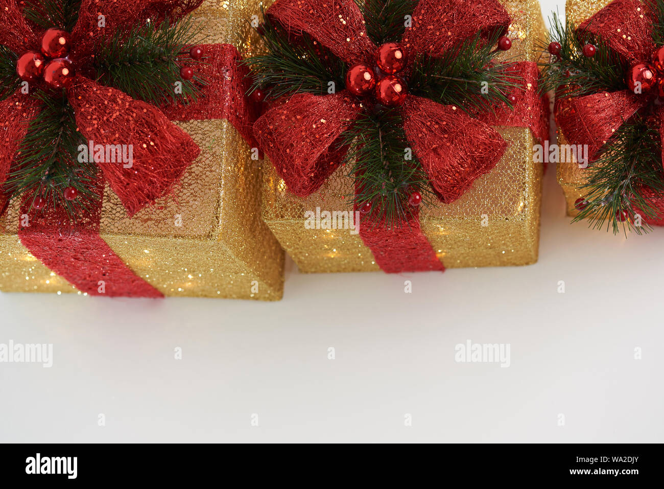 Christmas gifts theme. Gold color presents boxes with red ribbon Stock Photo
