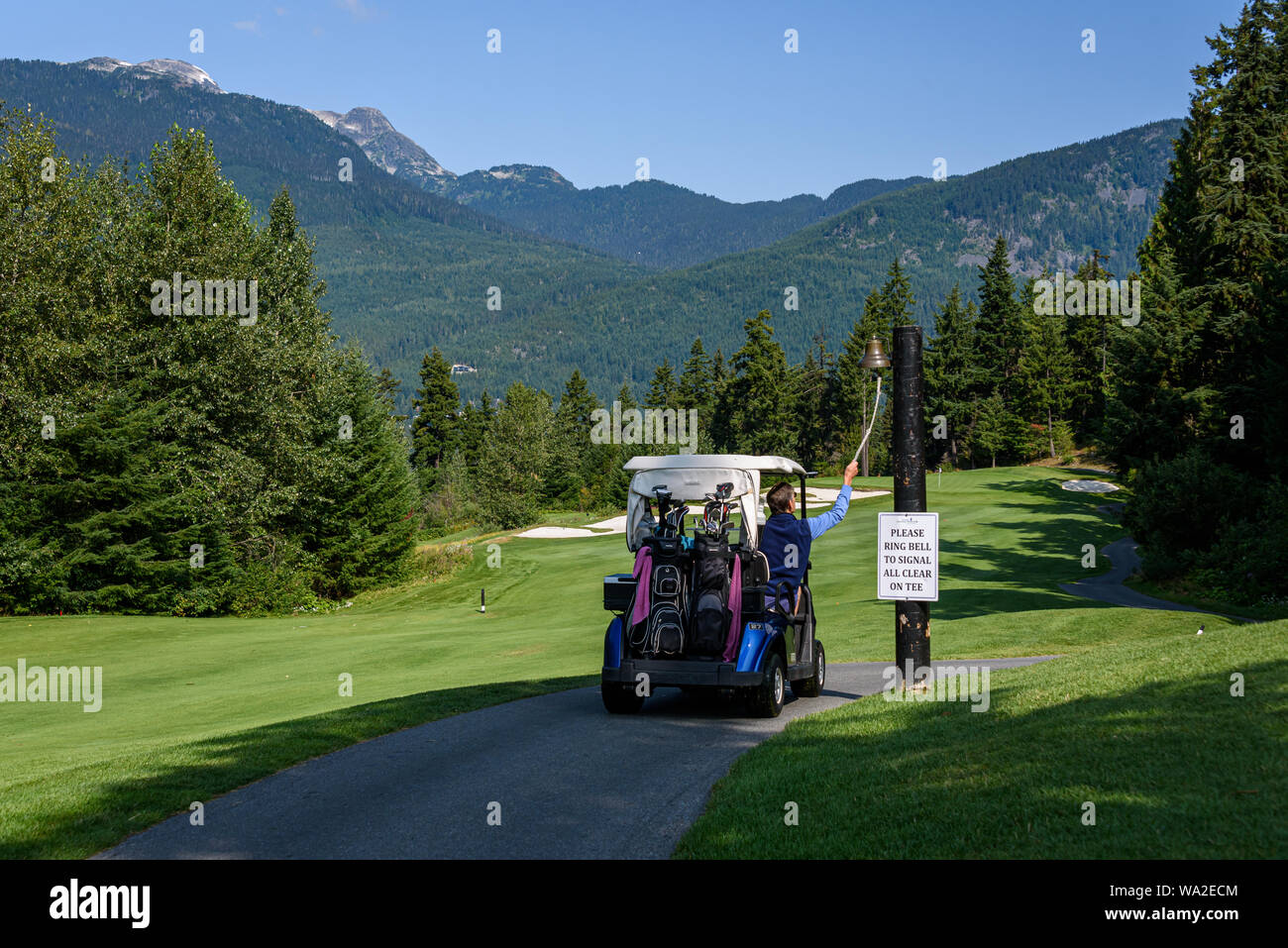 WHISTLER, BC/CANADA – AUGUST 3, 2019: Fairmont Chateau Whistler Golf Club, unknown man ringing signal bell on a sunny day. Stock Photo