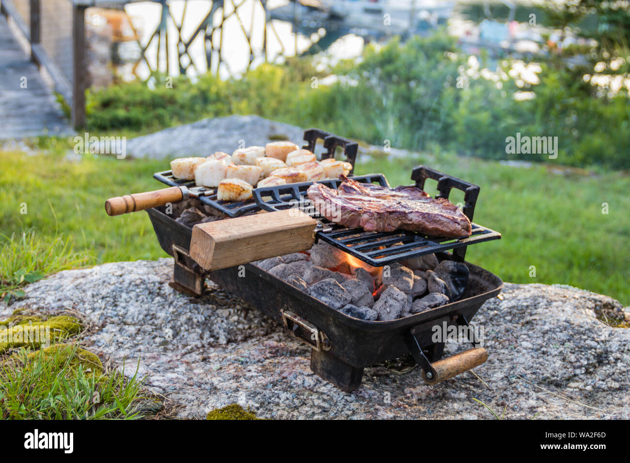 Steak and Scallops grilling on a Hibachi as smoke and flames develop from hot charcoal on a sunny summer evening Stock Photo Alamy