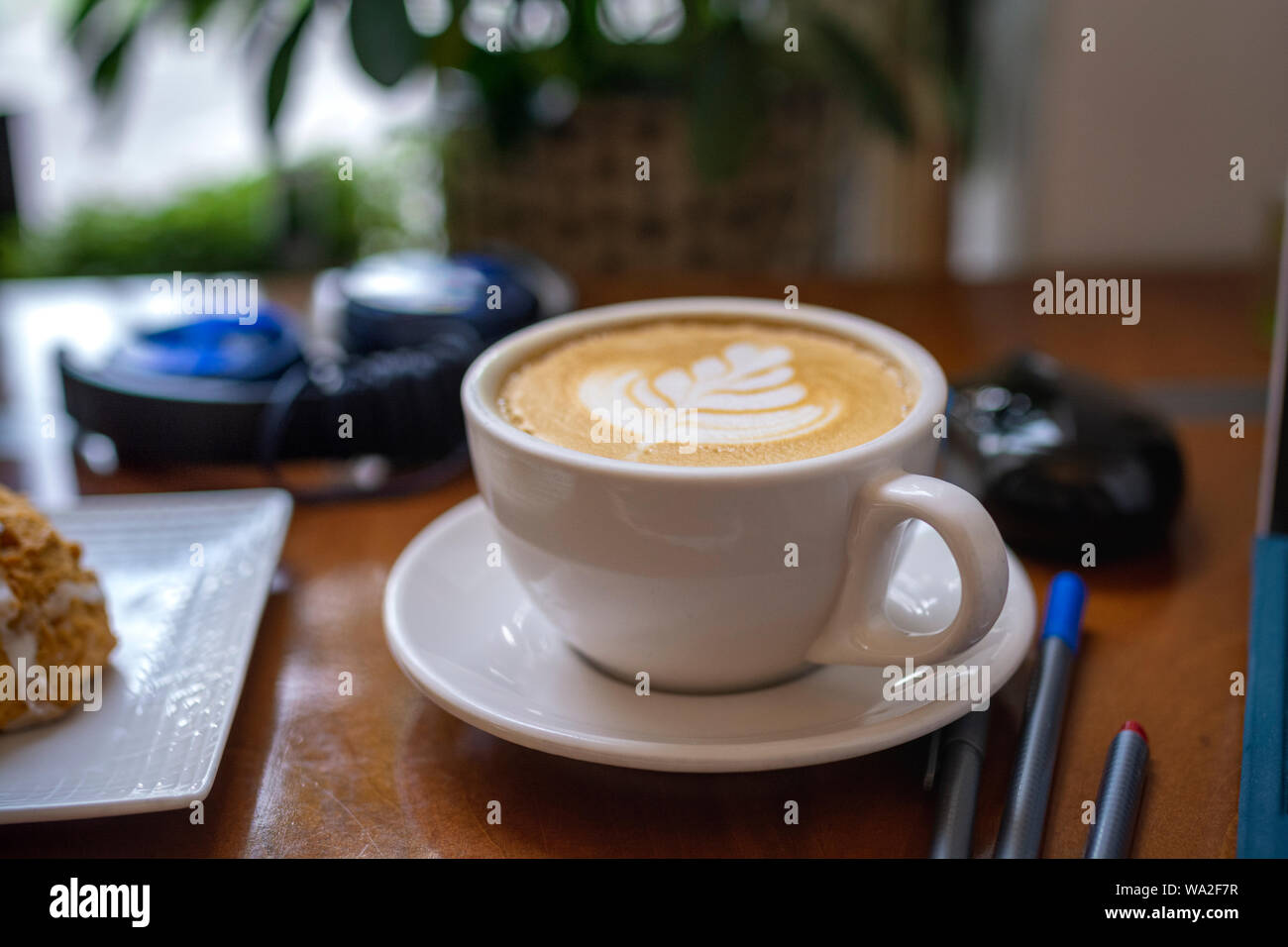 Studying wiht a delicious latte surounded by study materials and electronics. Stock Photo