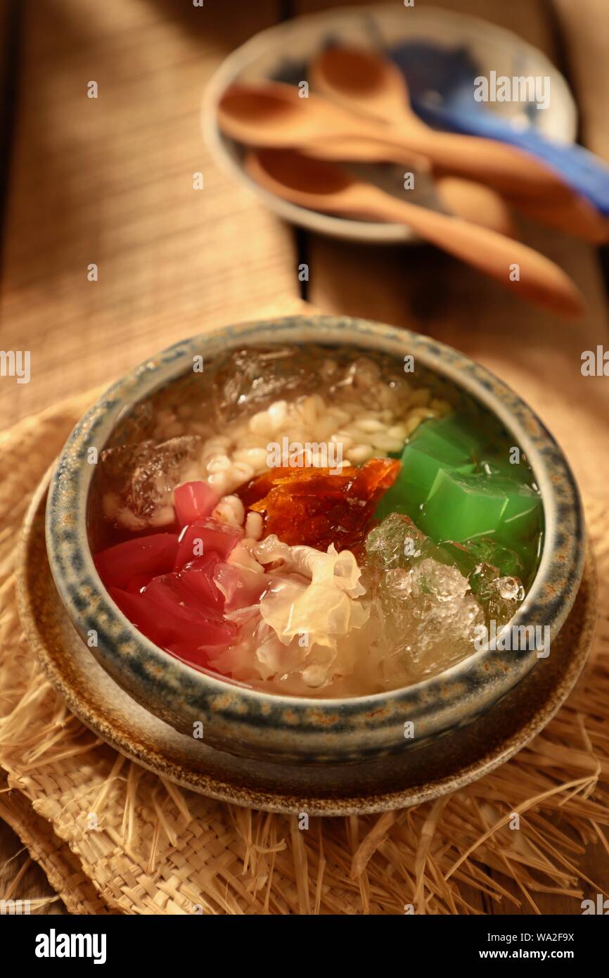 Es Sekoteng Medan. Cooling dessert cocktail of barley, palm fruit, white fungus, agar jelly, and preserved kumquat with crushed ice in sugar water. Stock Photo